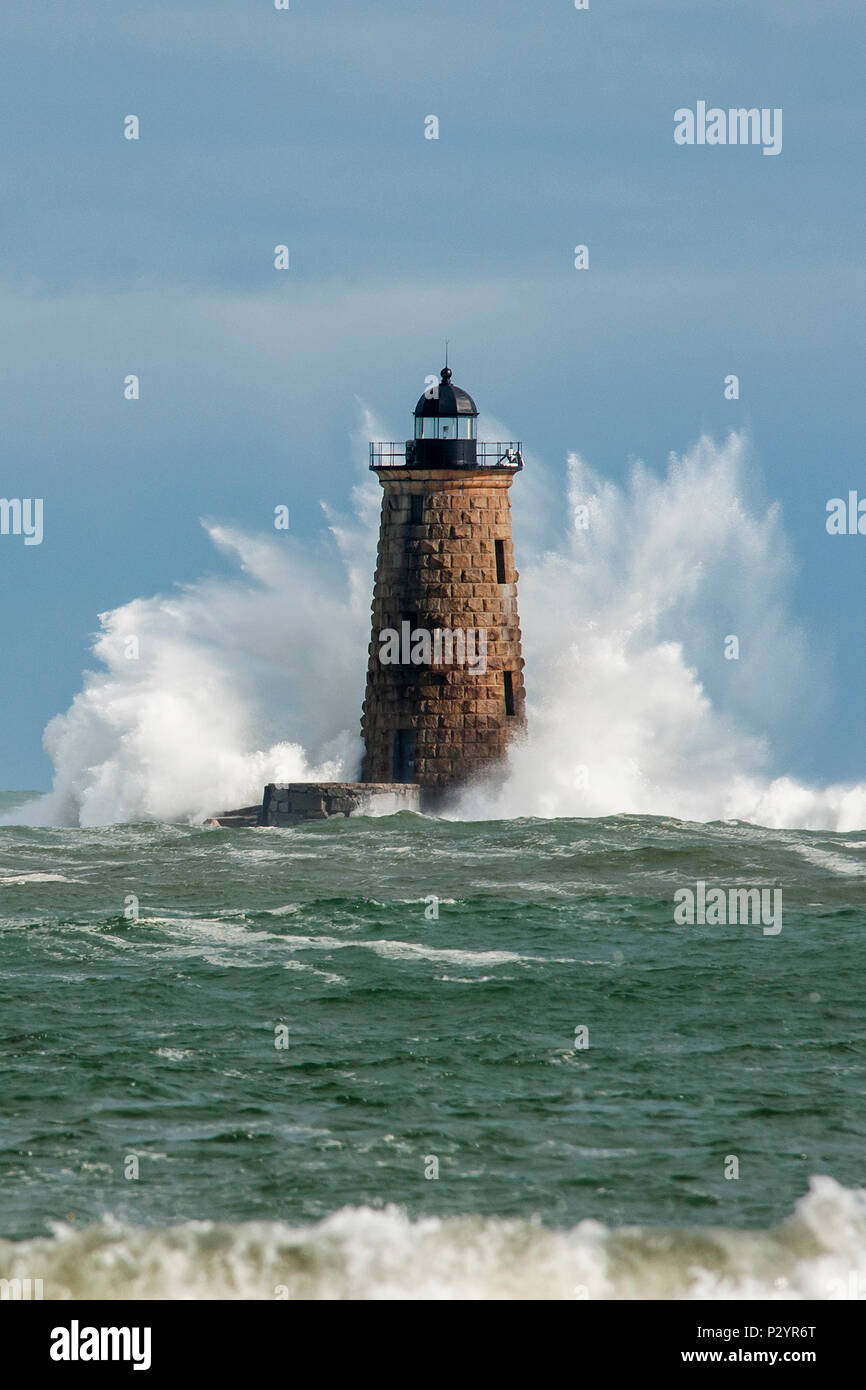Huge waves break around the stone tower of Whalback lighthouse in Maine during rare high tide. Stock Photo