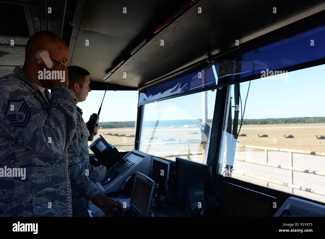 Master Sgt. Greylynn Carr and Master Sgt. Bradley Rich, 821st Contingency Response Squadron air traffic control craftsmen, watch the skies and the flightline from the air traffic control tower Aug. 8, 2016, at Grayling Army Airfield, Michigan. Both Carr and Rich are stationed at Travis Air Force Base, California, and were in Michigan as part of Exercise Northern Strike. (U.S. Air Force photo by Senior Airman Amber Carter) Stock Photo
