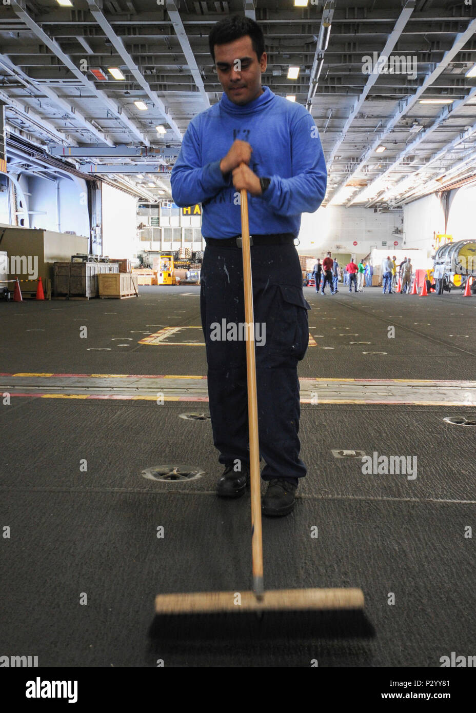 160812-N-KC543-068 ATLANTIC OCEAN (Aug. 12, 2016) - Airman Agustin Moreno, from Los Angelos, sweeps the nonskid in the hangar bay as a part of cleaning stations, a daily evolution aboard the aircraft carrier USS George Washington (CVN 73). George Washington, homeported in Norfolk, is underway conducting carrier qualifications in the Atlantic Ocean. (U.S. Navy photo by Mass Comunication Specialist 3rd Class Alora R. Blosch) Stock Photo