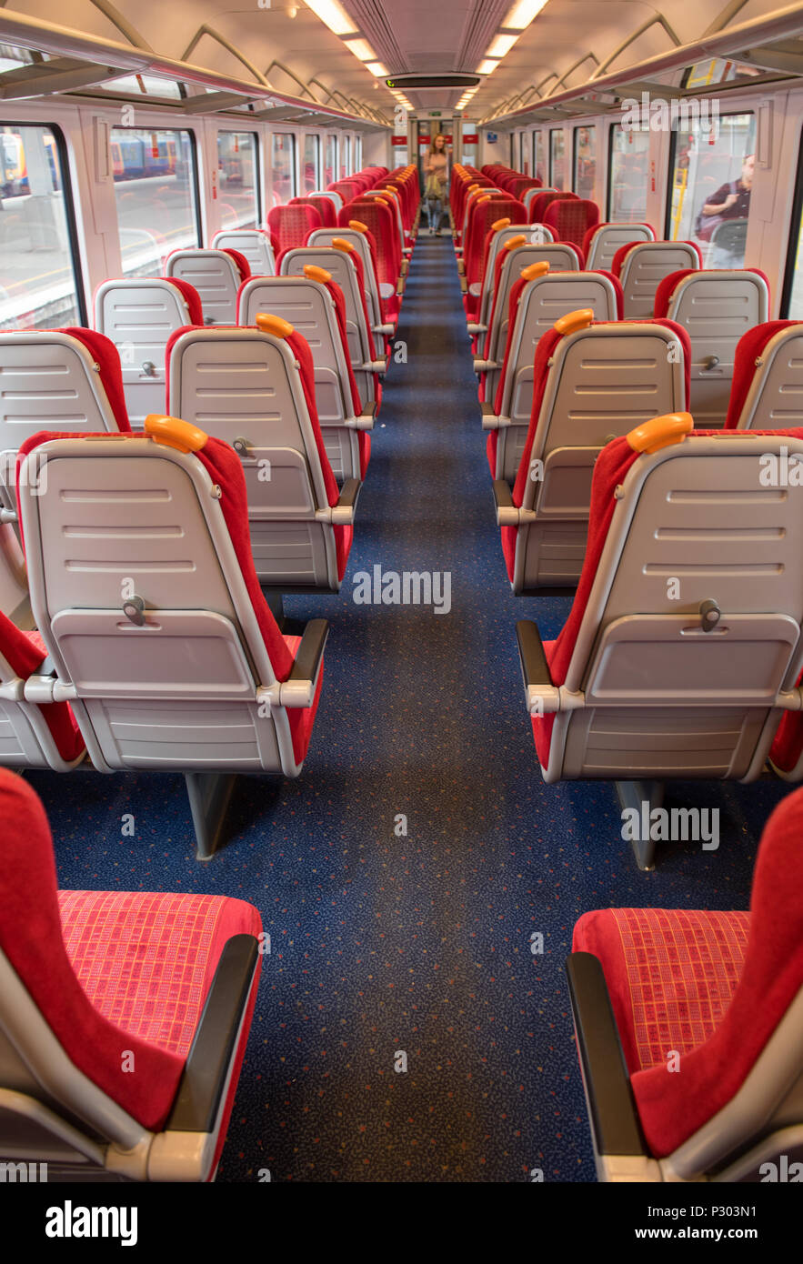 the inside or interior of a modern commuter railway train carriage or coach with upholstered seats and empty. modern rail coach rolling stock and seat Stock Photo