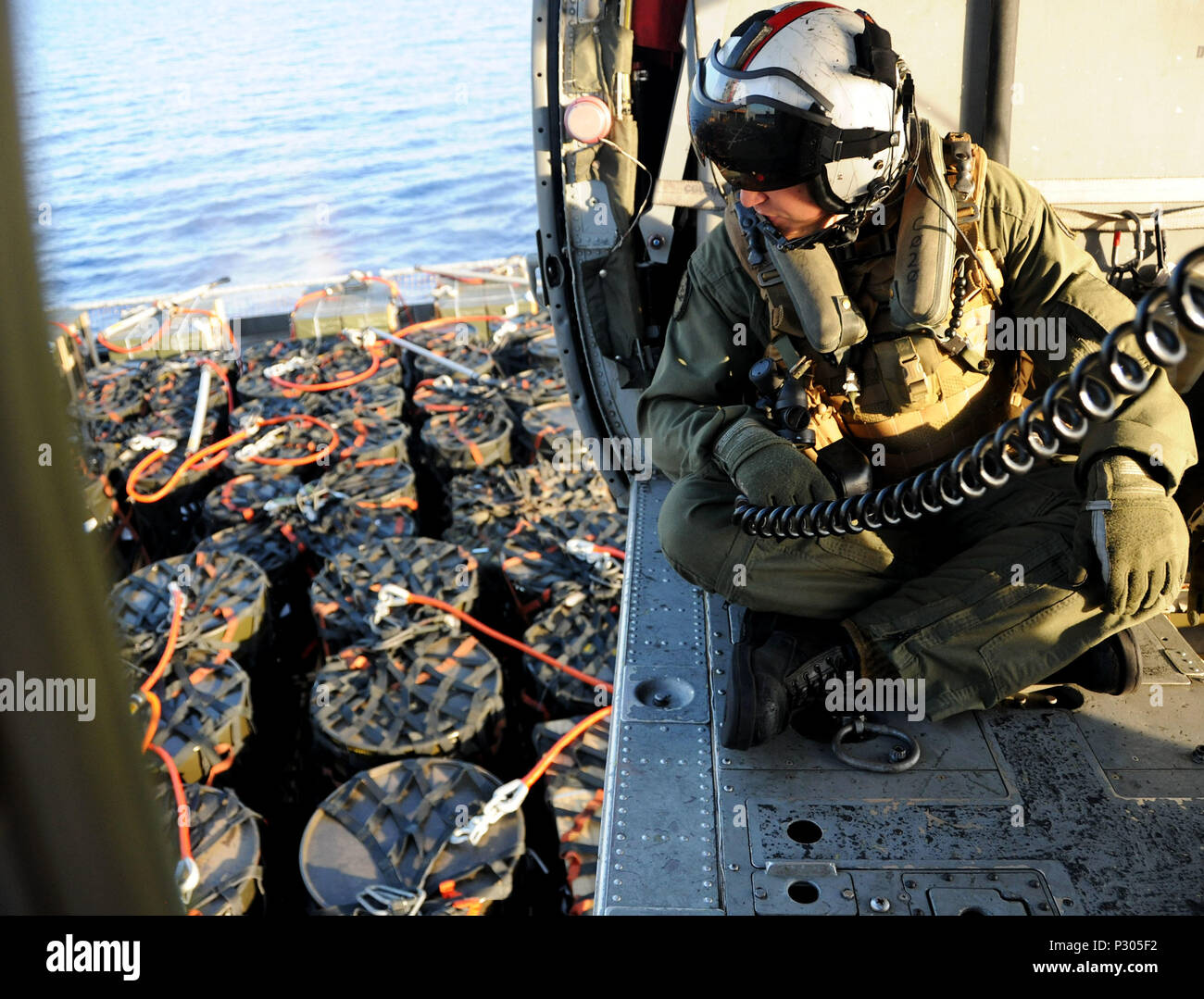 160816-N-XI307-305 ATLANTIC OCEAN (Aug. 16, 2016) Naval Air Crewman (Helicopter) 1st Class Michael Gionet coordinates the pick-up of ammunition during a vertical replenishment with the Military Sealift Command dry cargo and ammunition ship USNS Robert E. Peary (T-AKE 5) aboard an MH-60S helicopter attached to the “Tridents” of Helicopter Sea Combat Squadron (HSC) 9. USS George H.W. Bush (CVN 77) took on 4 million pounds of live ammunition during the underway and vertical replenishment. GHWB is underway conducting training and qualifications in preparation for a 2017 deployment. (U.S. Navy phot Stock Photo
