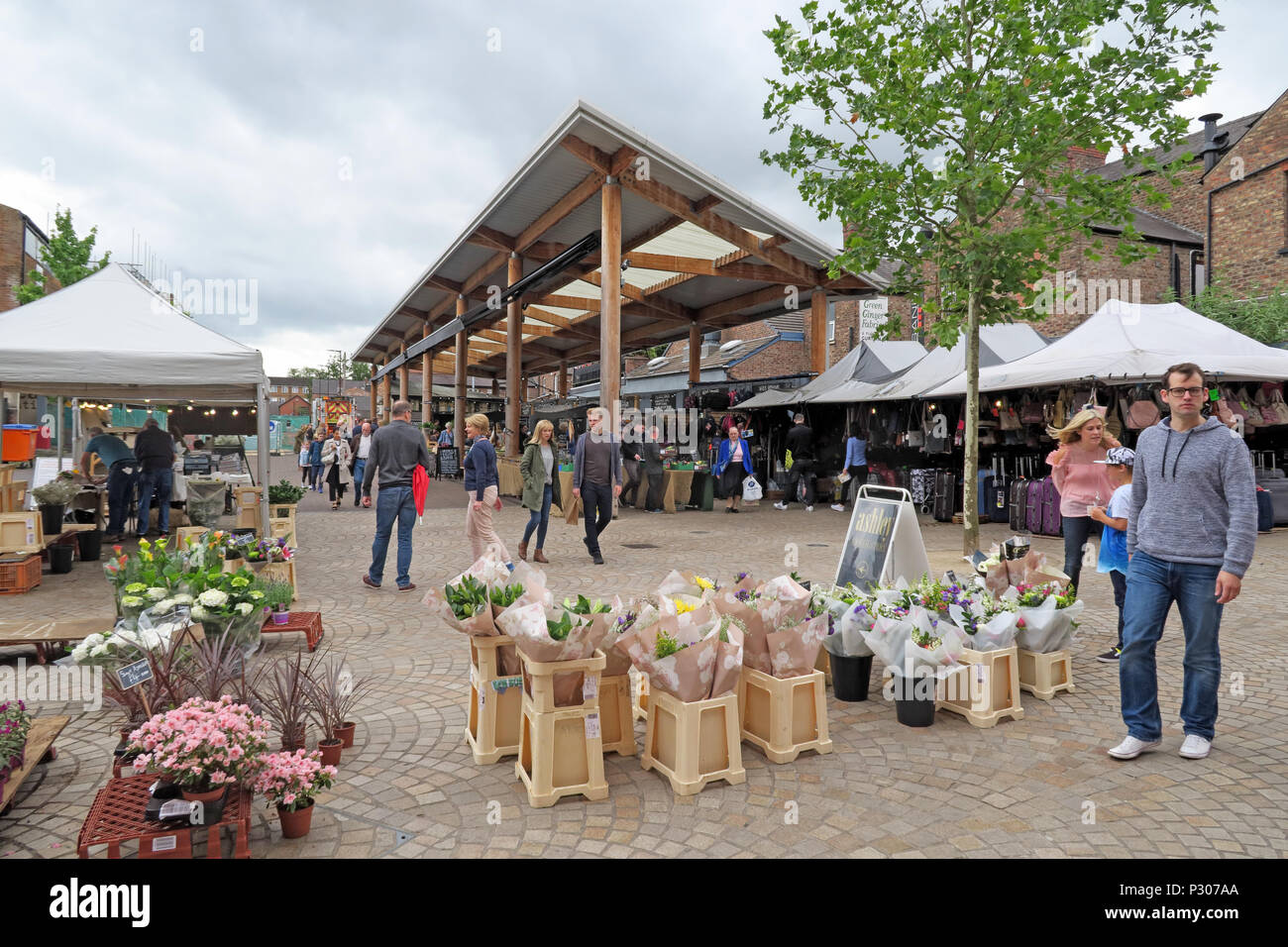 Flower stall outside Altrincham Market, Greenwood Street, Trafford, with shoppers at the regenerated old market square,enterprising retail destination Stock Photo