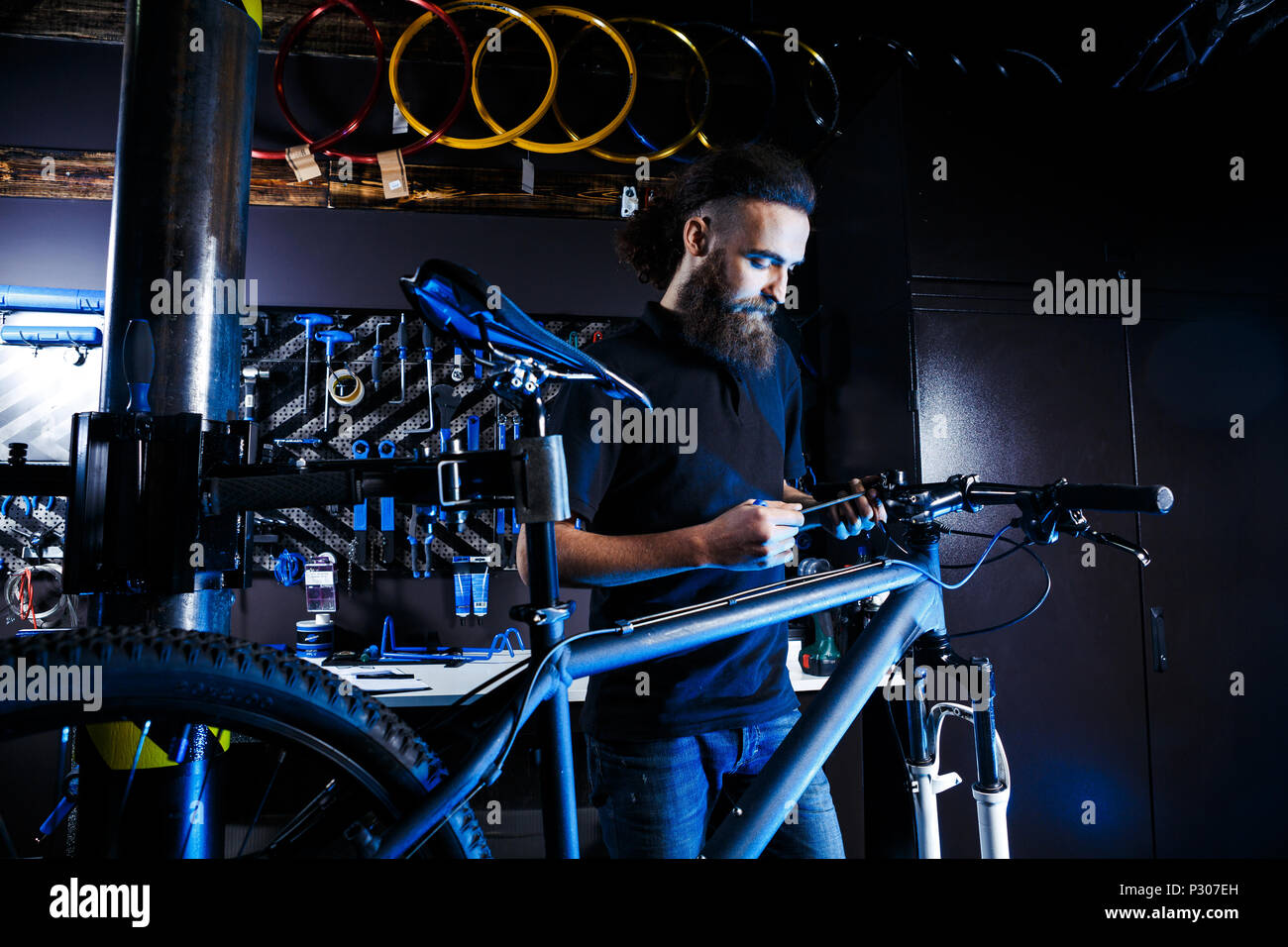 Theme sale and repair of bicycles. Young and stylish with a beard and long hair, a Caucasian man