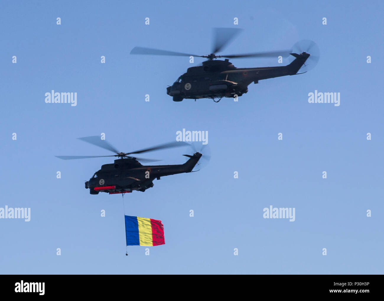 Two Romanian helicopters fly over a delighted crowd of spectators while carrying the Romanian flag during the 114th annual Navy Day celebration at the Port of Constanţa, Romania, Aug. 15, 2016. U.S. Sailors and Marines supporting the Black Sea Rotational Force 16.2 helped pay tribute to the prestigious history of the Romanian navy and highlighted the military’s movement toward new developments and modernizations. Black Sea Rotational Force is an annual multilateral security cooperation activity between the U.S. Marine Corps and partner nations in the Black Sea, Balkan and Caucasus regions desi Stock Photo