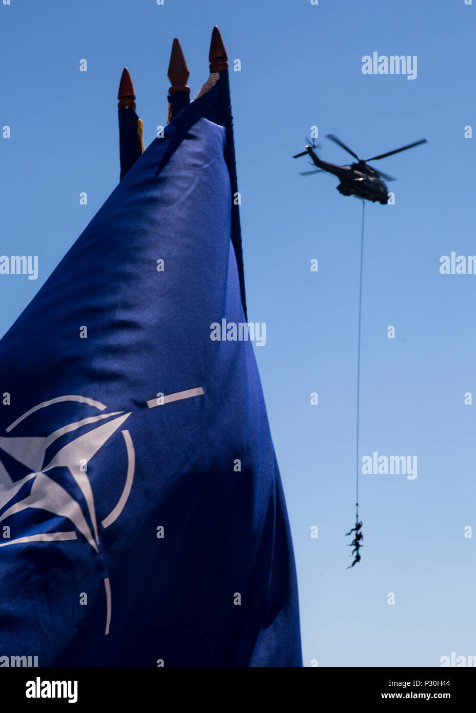 Three Romanian sailors hang suspended from a helicopter while a delighted crowd spectates during the 114th annual Navy Day celebration at the Port of Constanţa, Romania, Aug. 15, 2016. U.S. Sailors and Marines supporting the Black Sea Rotational Force 16.2 helped pay tribute to the prestigious history of the Romanian navy and highlighted the military’s movement toward new developments and modernizations. Black Sea Rotational Force is an annual multilateral security cooperation activity between the U.S. Marine Corps and partner nations in the Black Sea, Balkan and Caucasus regions designed to e Stock Photo