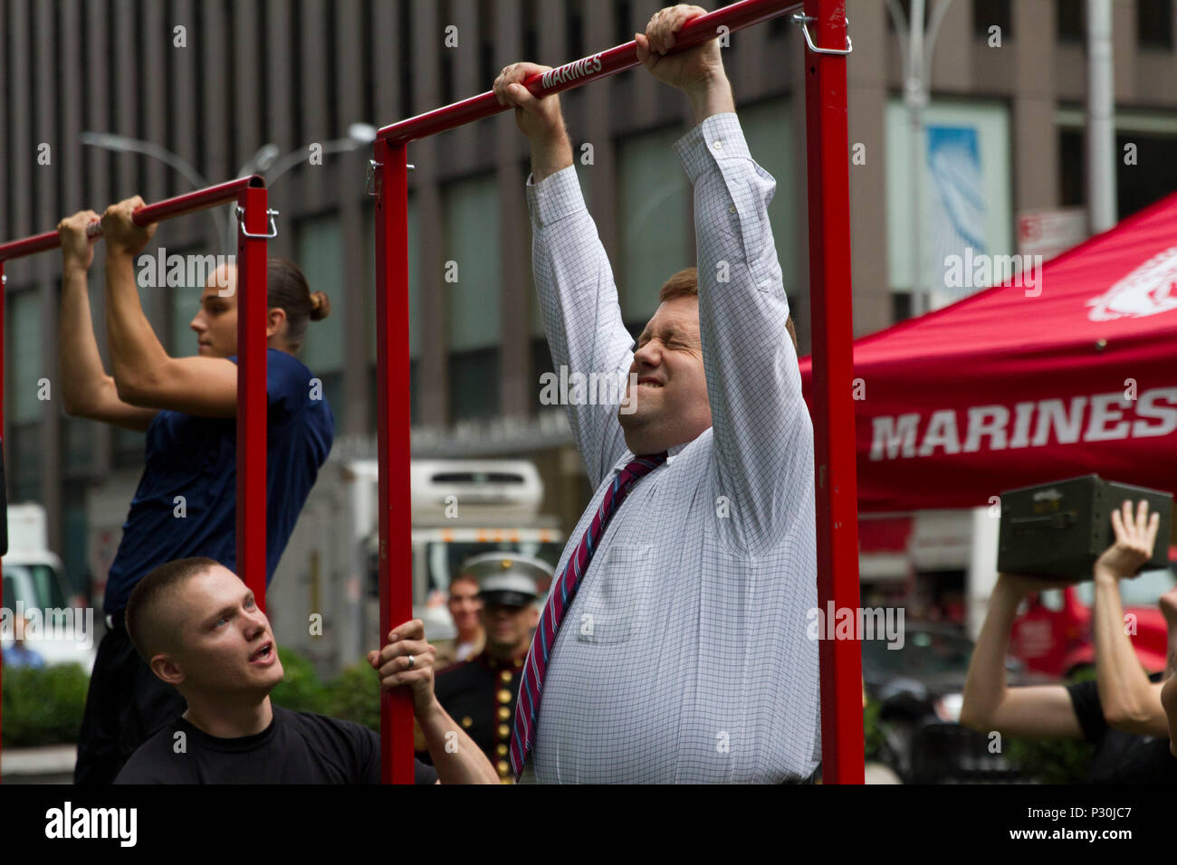 Frank Luntz, a political consultant with Fox News, attempts the pull-up challenge outside of the Fox News building in New York City, Aug. 17, 2016. The Marines visited Fox & Friends, a popular morning show, to demonstrate their commitment to female Marines and to the integration of women into combat military occupational specialties. Stock Photo