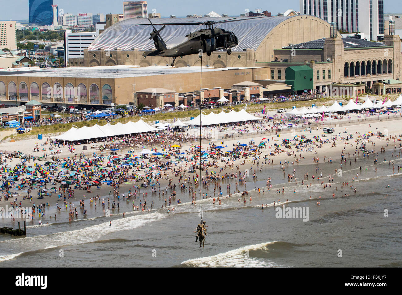 Tactical Air Control Party Airmen with New Jersey Air National Guard's 227th Air Support Operations Squadron, give a Special Purpose Insertion Extraction (SPIES) demonstration at the 2016 Atlantic City Airshow above the Atlantic City, N.J., boardwalk Aug. 17, 2016. The Airmen are being flown by UH-60 Black Hawks with the 1-150th Assault Helicopter Battalion, New Jersey Army National Guard. SPIES is used for extracting special operations personnel when an aircraft cannot land. The 1-150th is located at Joint Base McGuire-Dix-Lakehurst while the 227th is located at the Atlantic City Air National Stock Photo