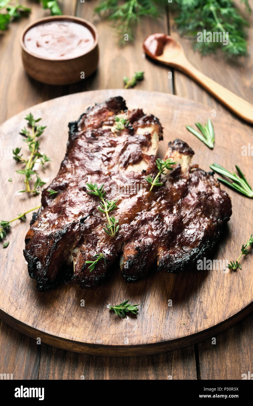 Grilled pork ribs on wooden board, shallow depth of field Stock Photo