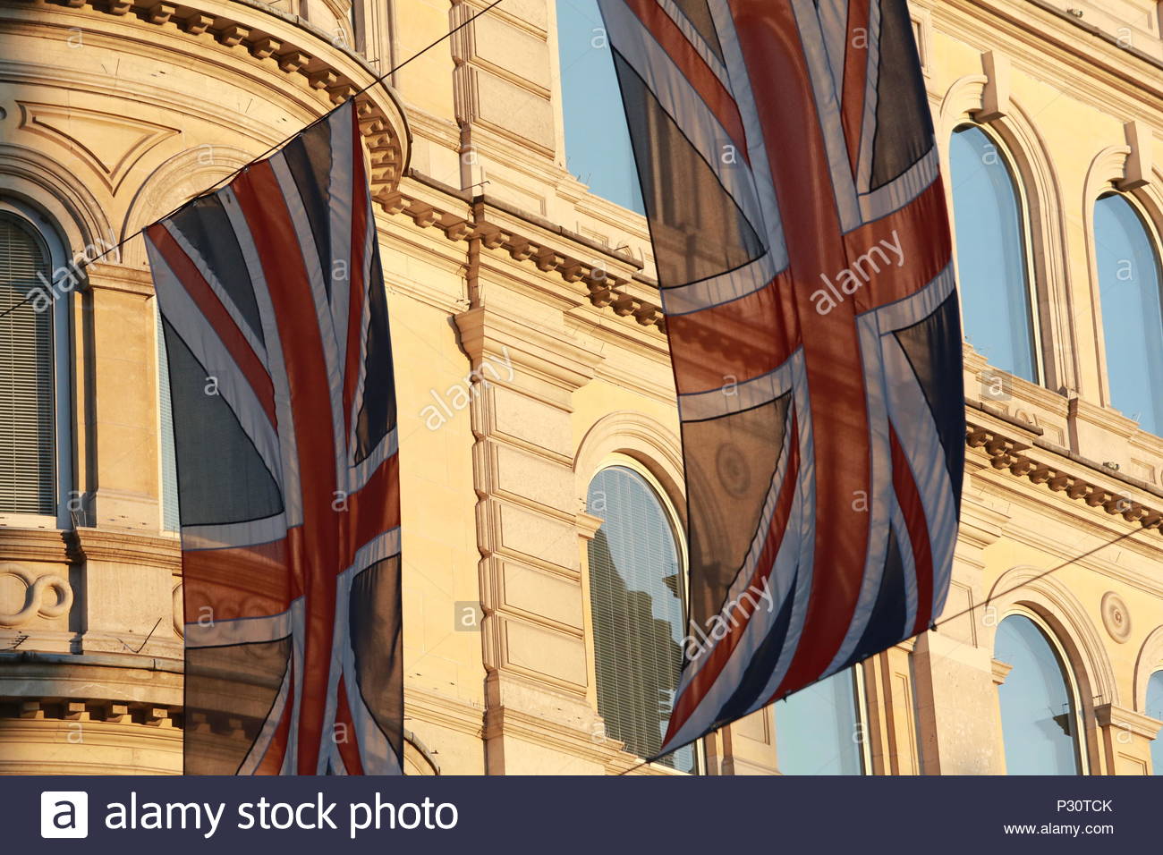 Two union jacks hang side by side on a glorious evening in Central London Stock Photo