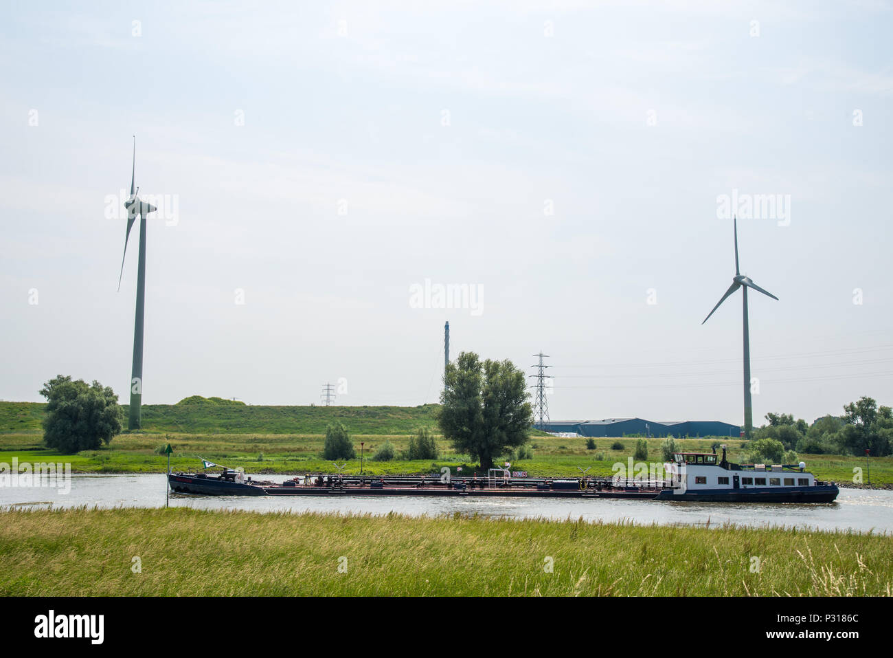 boat at river IJssel and windmills at Overijssel, Holland Stock Photo