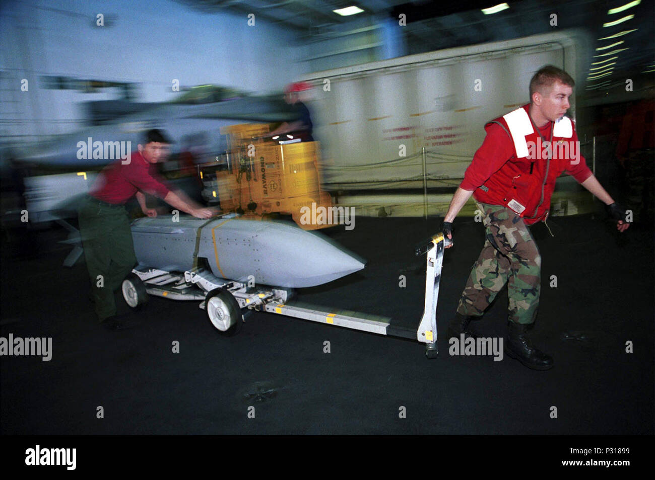 Arabian Gulf (Feb. 16, 2001) -- Aviation Ordnancemen break out Joint Stand Off Weapons (JSOWs) in the hangar bay aboard USS Harry S. Truman (CVN 75) prior to night flight operations in support of Operation Southern Watch.  Truman is on station in the Arabian Gulf in support of Operation Southern Watch. Stock Photo