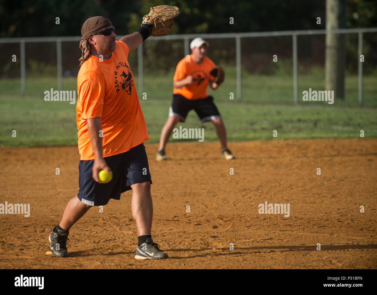 Mike Trader, 438th Special Operations Group F-16 mission capability deputy flight chief, throws a pitch during the 2016 Intramural Softball Championship game at Langley Air Force Base, Va., Aug. 10, 2016. The intramural sports program aims to promote physical fitness, morale and esprit de corps through athletic competition. Stock Photo