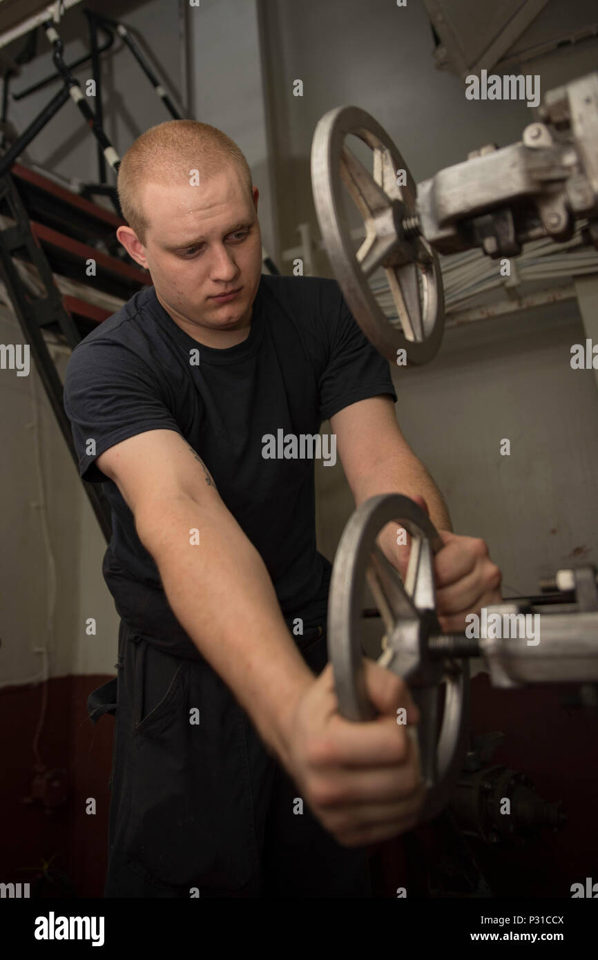160823-N-WC455-058    ARABIAN GULF (Aug. 23, 2016) Machinist's Mate Fireman Alex Schuessler, from Pittsburgh, Pa., drains water from a reservoir in the number one reboiler space of the aircraft carrier USS Dwight D. Eisenhower (CVN 69) (Ike). Ike and its Carrier Strike Group are deployed in support of Operation Inherent Resolve, maritime security operations and theater security cooperation efforts in the U.S. 5th Fleet area of operations. (U.S. Navy photo by Mass Communication Specialist Seaman Joshua Murray) Stock Photo