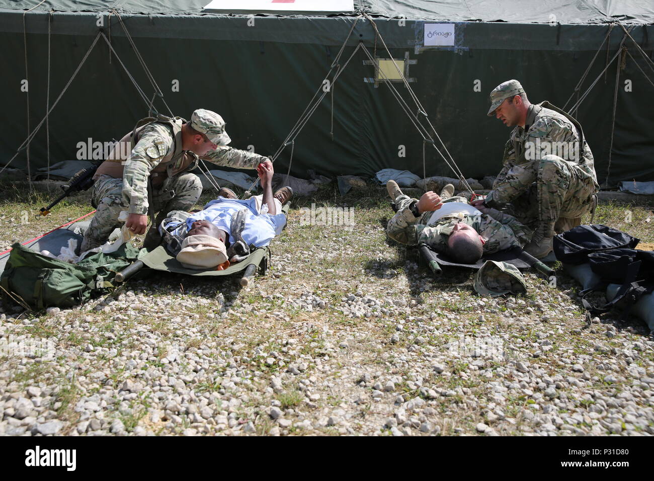 Georgian soldiers of the 32nd Infantry Battalion perform first aid on simulated casualties while conducting a mass casualty scenario during a mission rehearsal exercise (MRE) at the Joint Multinational Readiness Center in Hohenfels, Germany, Aug. 20, 2016. The MRE is a U.S.M.C. lead exercise involving over 1,100 Soldiers from Georgia, Hungary and the U.S. The MRE is based on the current operational environment and incorporates lessons learned in order to prepare the Georgian’s 32nd Infantry Battalion for offensive, defensive, and deployment in support of Operation Freedom Sentinel. (U.S. Army  Stock Photo