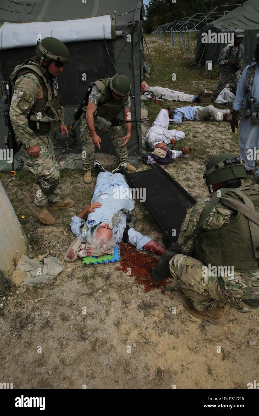 Georgian soldiers of the 32nd Infantry Battalion prepare to more a simulated wounded civilian role player while conducting a mass casualty scenario during a mission rehearsal exercise (MRE) at the Joint Multinational Readiness Center in Hohenfels, Germany, Aug. 20, 2016. The MRE is a U.S.M.C. lead exercise involving over 1,100 Soldiers from Georgia, Hungary and the U.S. The MRE is based on the current operational environment and incorporates lessons learned in order to prepare the Georgian’s 32nd Infantry Battalion for offensive, defensive, and deployment in support of Operation Freedom Sentin Stock Photo