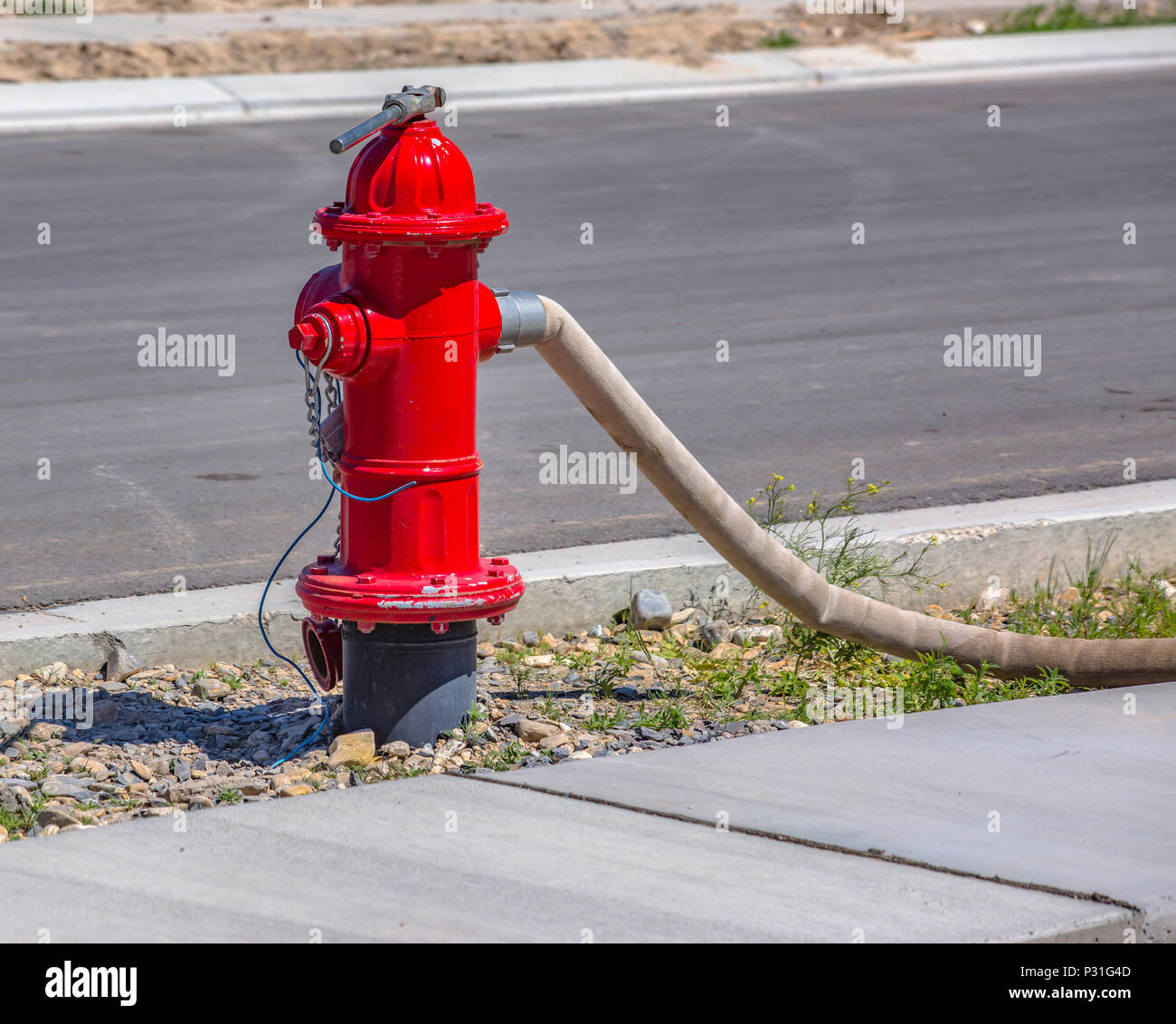 Red fire hydrant with hose connected for use in construction zone in Eagle  Mountain, Utah Stock Photo - Alamy