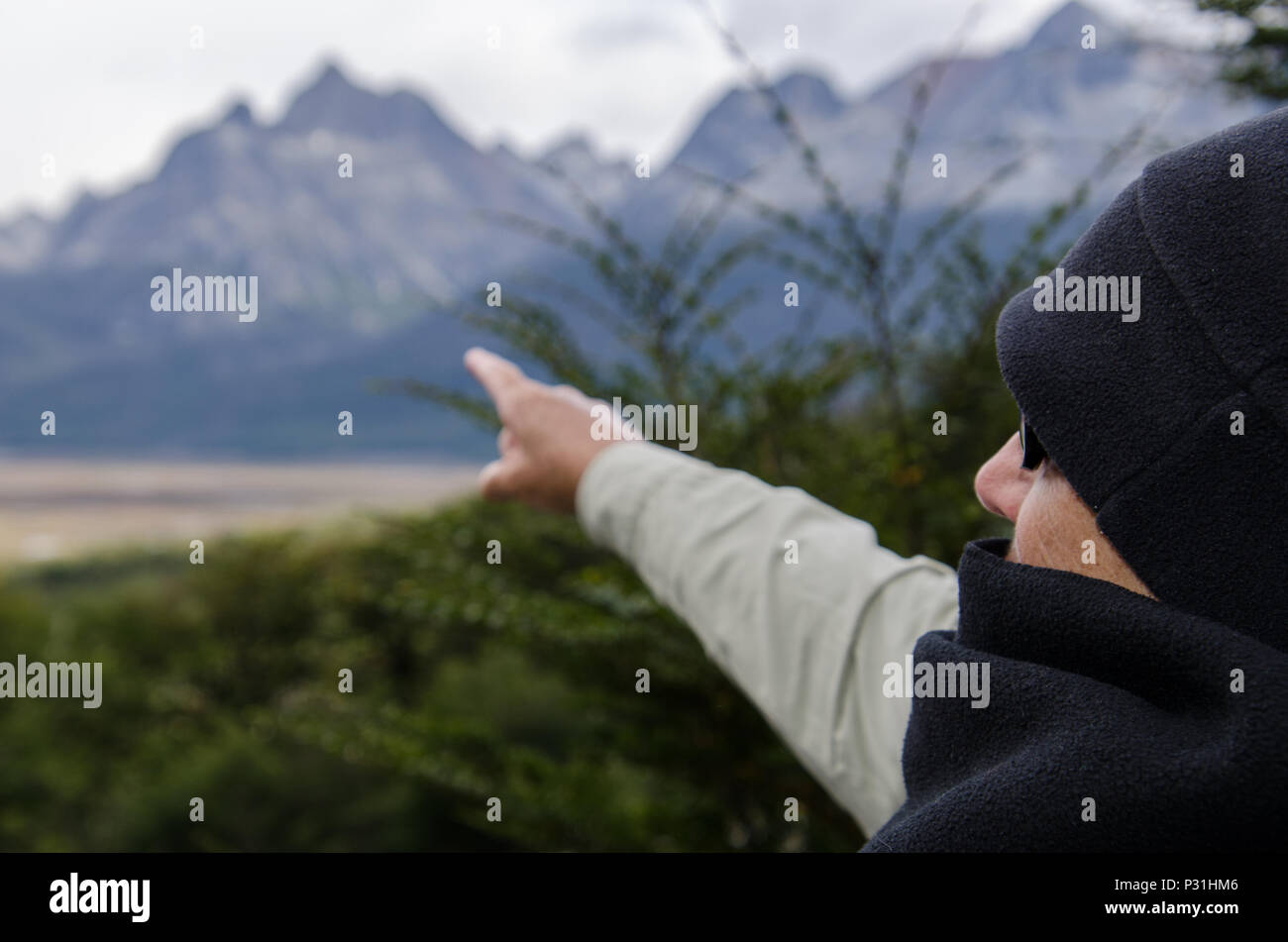 Head and shoulder view of women pointing finger to distance mountain