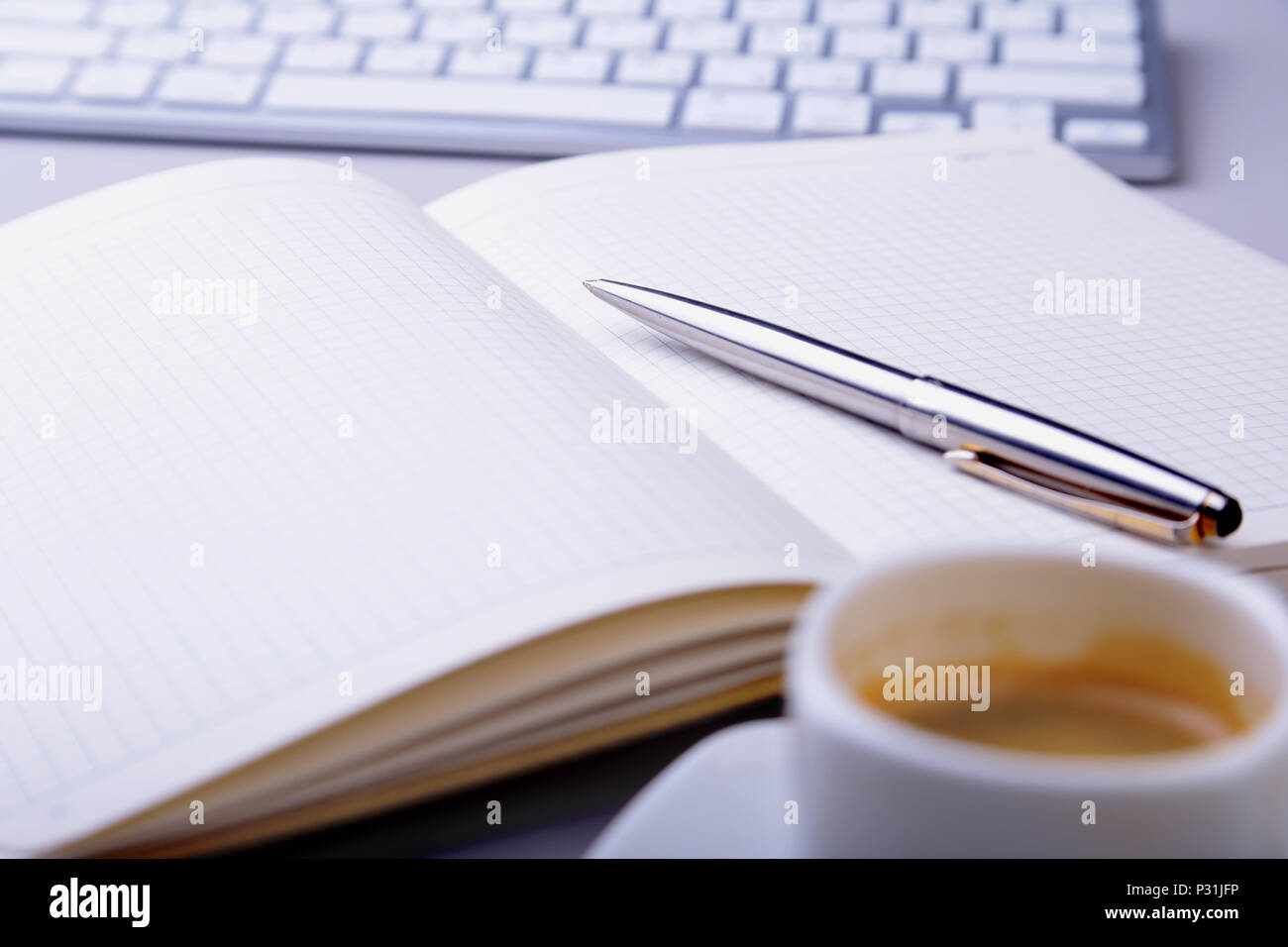 office table with notebook, computer keyboard,, cup of coffee, tablet pc. copy space. Stock Photo