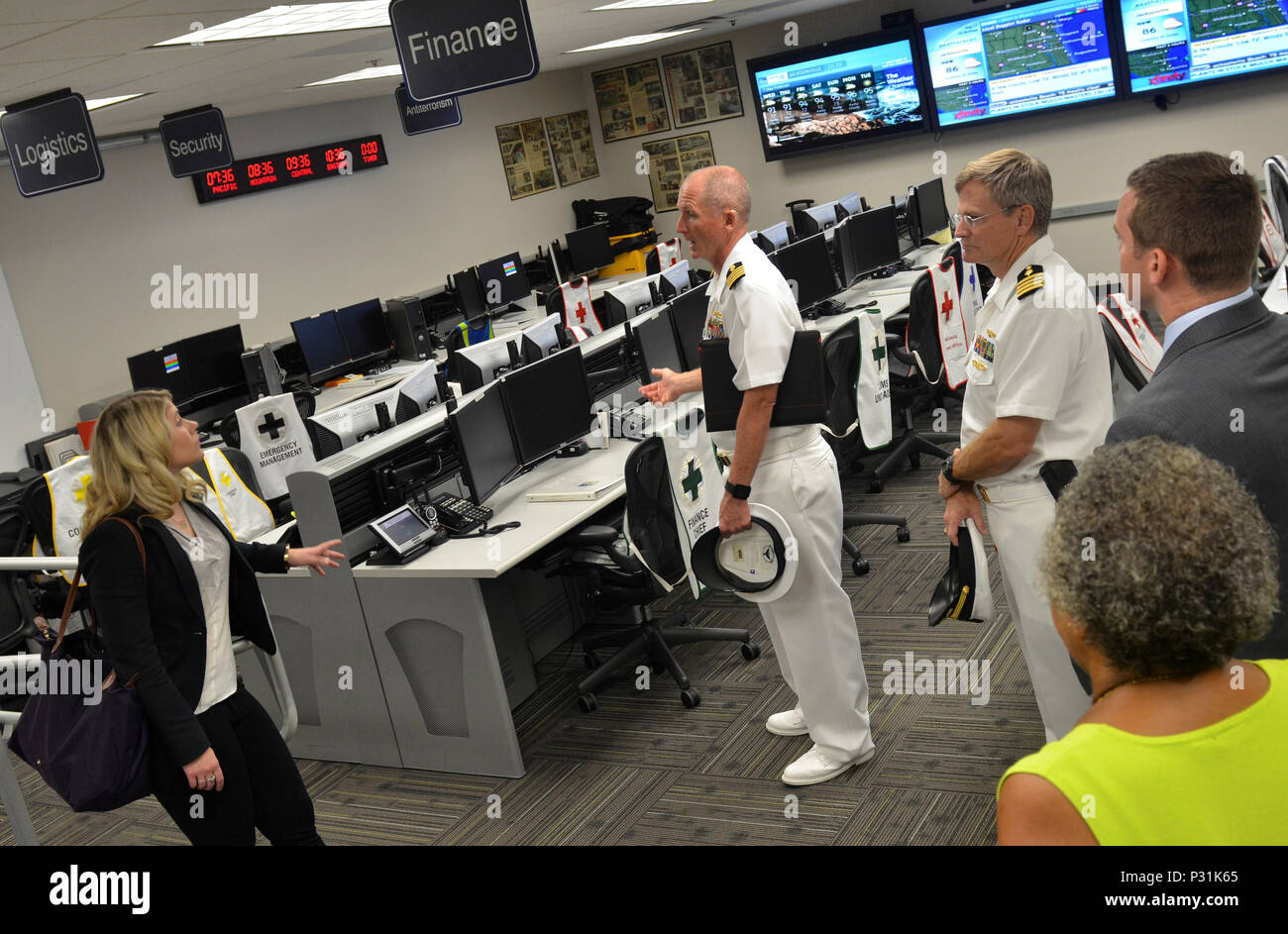 JACKSONVILLE, Fla. (Aug. 17, 2016) – Capt. David Collins, Naval Hospital (NH) Jacksonville commanding officer (center) and Capt. William Todd, executive officer, review the multi-functionality of the hospital’s emergency operations center with Caitlin Poling, national security advisor for Sen. David Perdue of Georgia.  Poling was briefed on regional public health and emergency preparedness.  Poling also toured Navy Region Southeast and Navy Entomology Center of Excellence during her visit to Naval Air Station Jacksonville.  NH Jacksonville's priority since its founding in 1941 is to heal the n Stock Photo