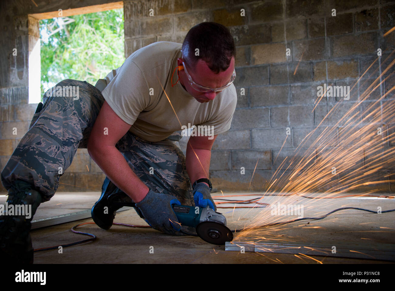 MALOJLOJ, Guam -- Airman 1st Class William Bush, a structures journeyman with the 134th Air Refueling Wing Civil Engineering squadron, cuts a metal stud to prepare for interior framing of a home.  The Airmen are working on two Habitat for Humanity homes in Guam as part of a government initiative that allows military assets the opportunity to assist non-profit organizations in conjunction with scheduled annual training. (Air National Guard photo by Tech. Sgt. Jonathan Young) Stock Photo