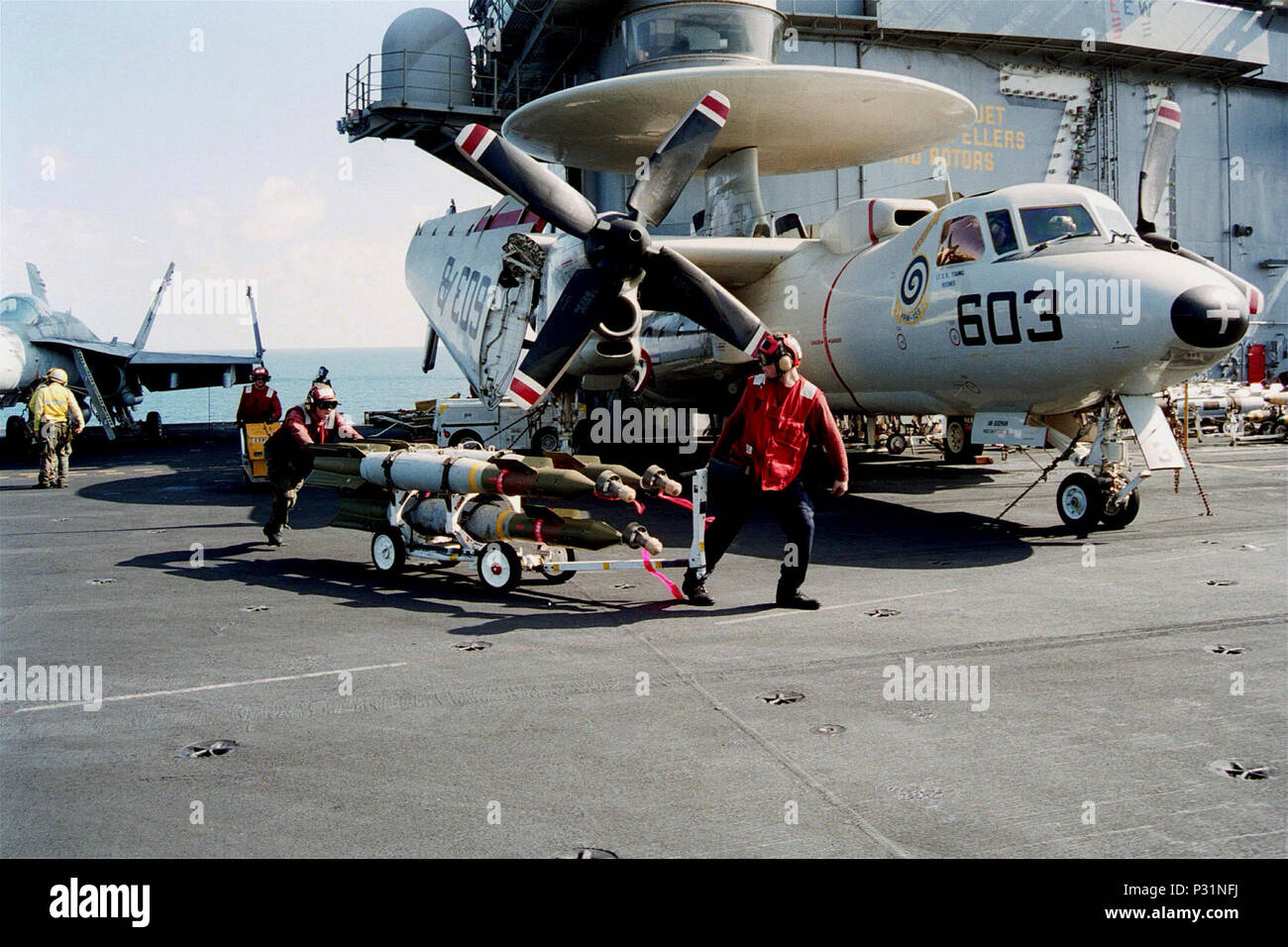 sea aboard USS Theodore Roosevelt (CVN 71) Dec. 18, 2001 -- Aviation Ordnancemen transport munitions across the flight deck aboard USS Theodore Roosevelt.  The Roosevelt is operating in support of Operation Enduring Freedom. Stock Photo