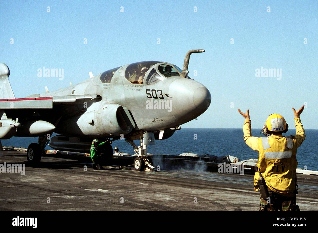 sea aboard USS Theodore Roosevelt (CVN 71) Dec. 19, 2001 -- A plane director guides an EA-6B Prowler from the Rooks of Tactical Electronic Warfare Squadron One Three Seven (VAQ-137) onto catapult number four on USS Theodore Roosevelt.  The Rooks are part of Carrier Air Wing One (CVW 1) deployed on the nuclear aircraft carrier in support of Operation Enduring Freedom. Stock Photo