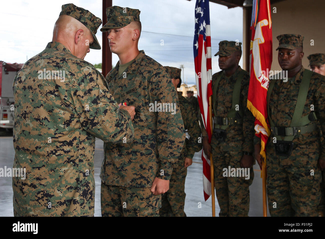Commandant of the Marine Corps Gen. Robert B. Neller, left, pins a Navy and Marine Corps Medal on Lance Cpl. Duncan Harris, automotive maintenance technician, at Soto Cano Air Base, Honduras, Aug. 21, 2016. Harris was awarded medal for saving a child from drowning. (U.S. Marine Corps photo by Cpl. Samantha K. Braun/Released) Stock Photo