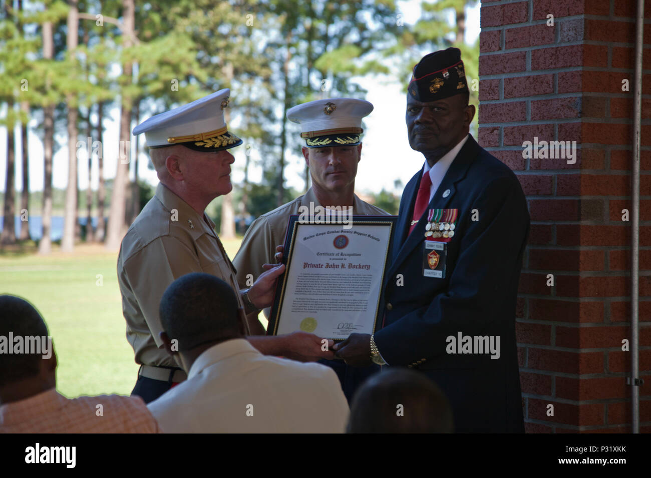 U.S. Marine Corps Maj. Gen. Walter L. Miller, Jr., commanding general of II Marine Expeditionary Force, left, and Col. David P. Grant, commanding officer of Marine Corps Combat Service Support Schools, center, present a certificate of recognition to Johnny Young on behalf of Pvt. John H. Dockery during the Montford Point Marines' ay ceremony held at Camp Johnson, N.C., August 25, 2016. The annual ceremony was held aboard Camp Johnson to celebrate the legacy of the original Montford Point Marines and the impact they had on the Marine Corps both past and present. (U.S. Marine Corps photo by Lanc Stock Photo