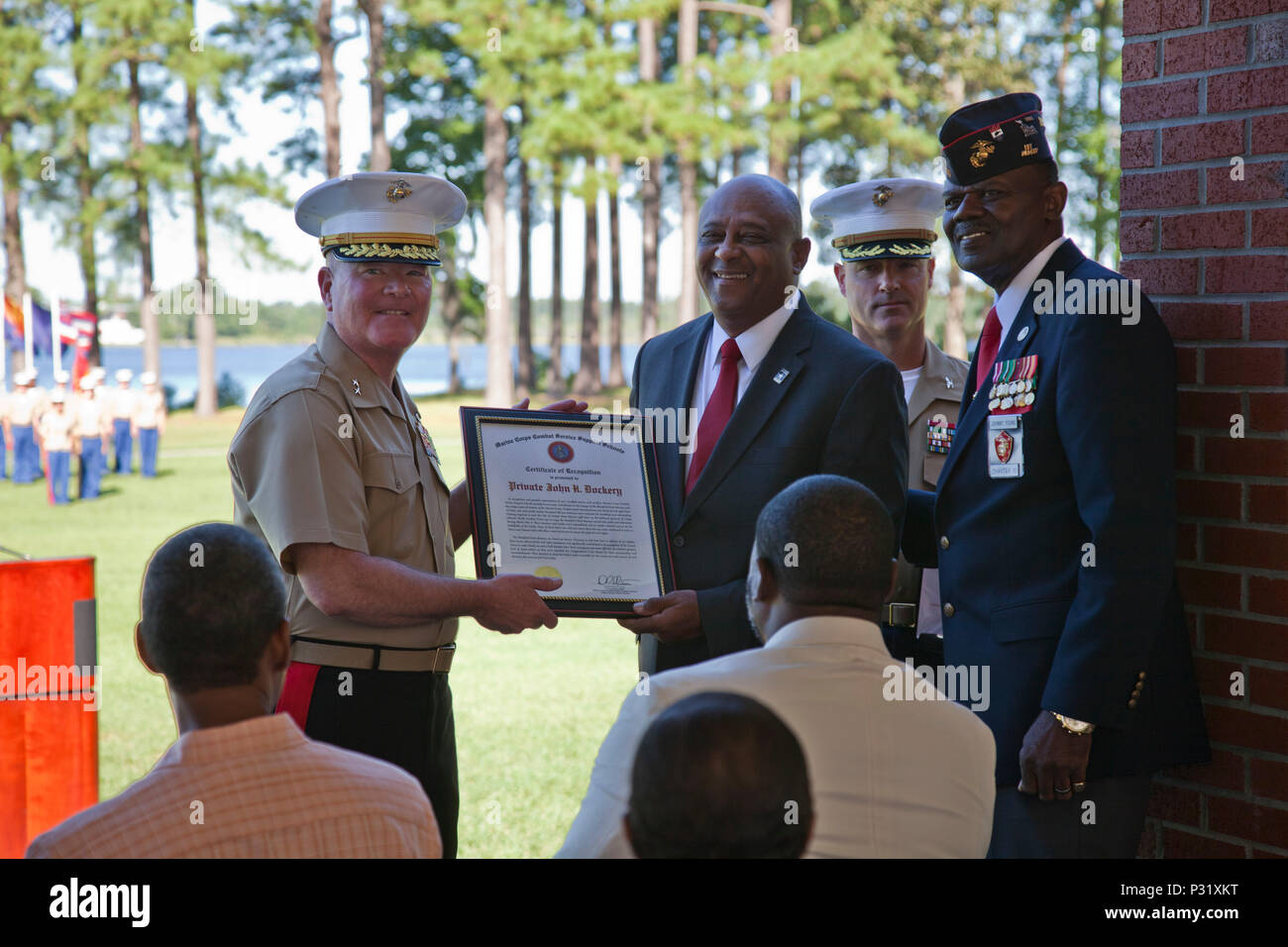 U.S. Marine Corps Maj. Gen. Walter L. Miller, Jr., commanding general of II Marine Expeditionary Force, far left, presents a certificate of recognition to retired. Lt. Col. John C. Dockery on behalf of Pvt. John H. Dockery during the Montford Point Marines'Day ceremony held at Camp Johnson, N.C., August 25, 2016. The annual ceremony was held aboard Camp Johnson to celebrate the legacy of the original Montford Point Marines and the impact they had on the Marine Corps both past and present. (U.S. Marine Corps photo by Lance Cpl. Jose Villalobosrocha) Stock Photo