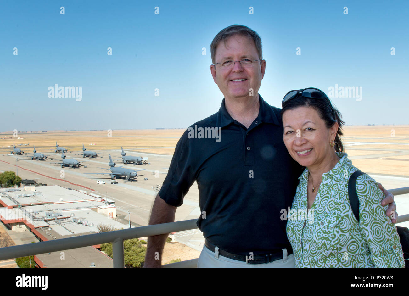 The President of the 2017 Tournament of Roses Parade, Mr. Brad Ratliff, with his wife Susan pause for a photo on the catwalk of the air traffic control tower during a recent visit. Mr. Ratliff was at Travis to present the Tournament of Roses flag to the U. S. Air Force Band of the Golden West.  As part of the visit, the Ratliffs visited the 621 CRW warehouse to learn more about their mission here at the base. (U.S. Air Force Photo by Heide Couch) Stock Photo