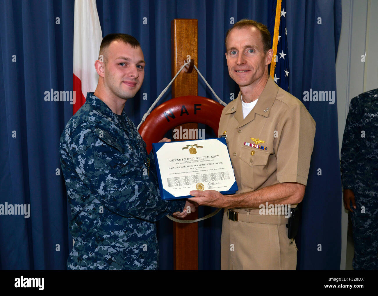 160825-N-OK605-005 MISAWA, Japan (June, 30 2016) Culinary Specialist 2nd Class Christopher Plowden, from New York City, receives a Navy and Marine Corps Achievement medal from Capt. Keith Henry, commanding officer Naval Air Facility Misawa. (U.S. Navy Photo by Mass Communication Specialist 2nd Class Samuel Weldin/Released) Stock Photo