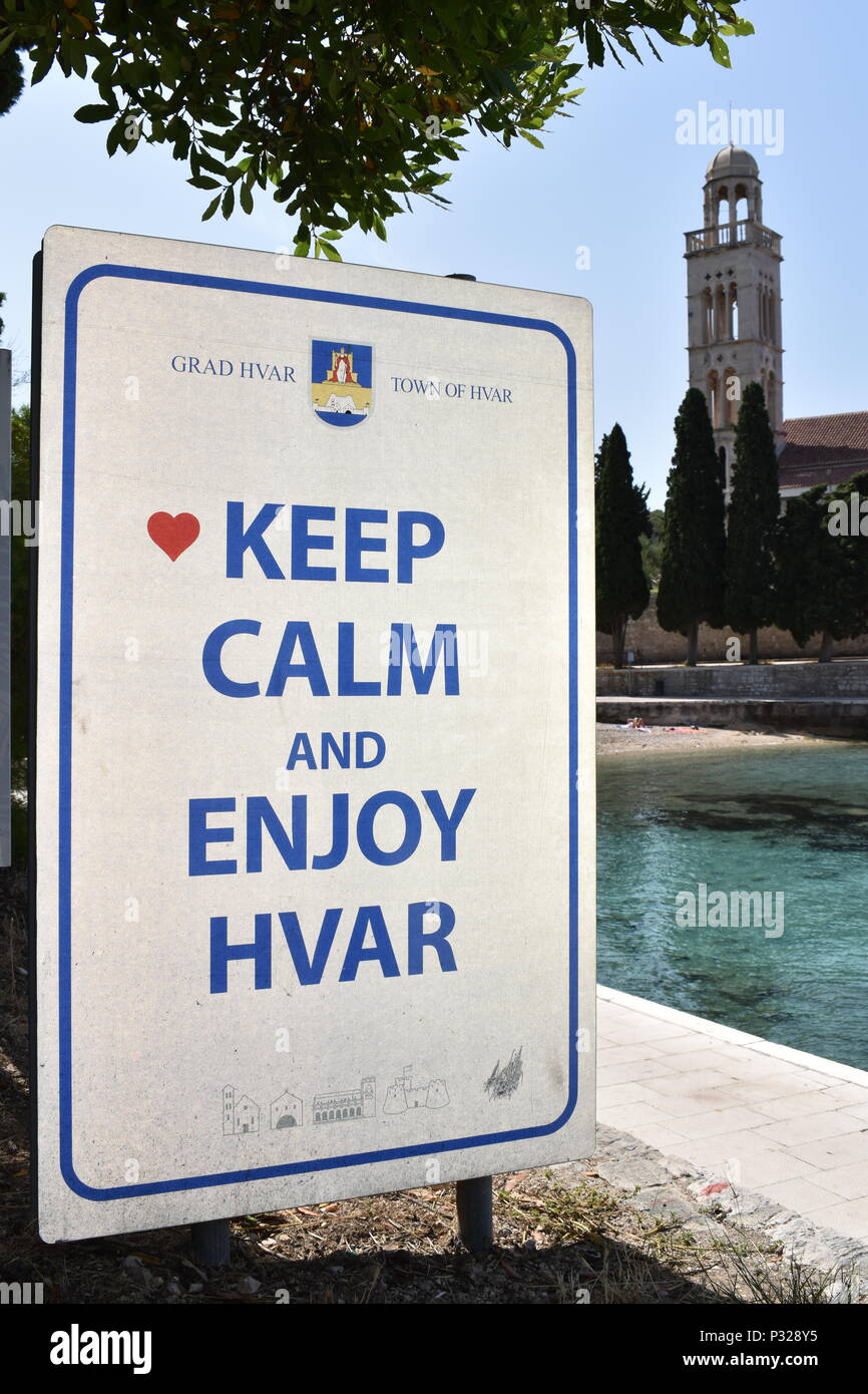 Sign located on Hvar island promenade with the Keep Calm-o-matic theme. Bell tower at the background. Hvar island, Croatia, June 2018 Stock Photo