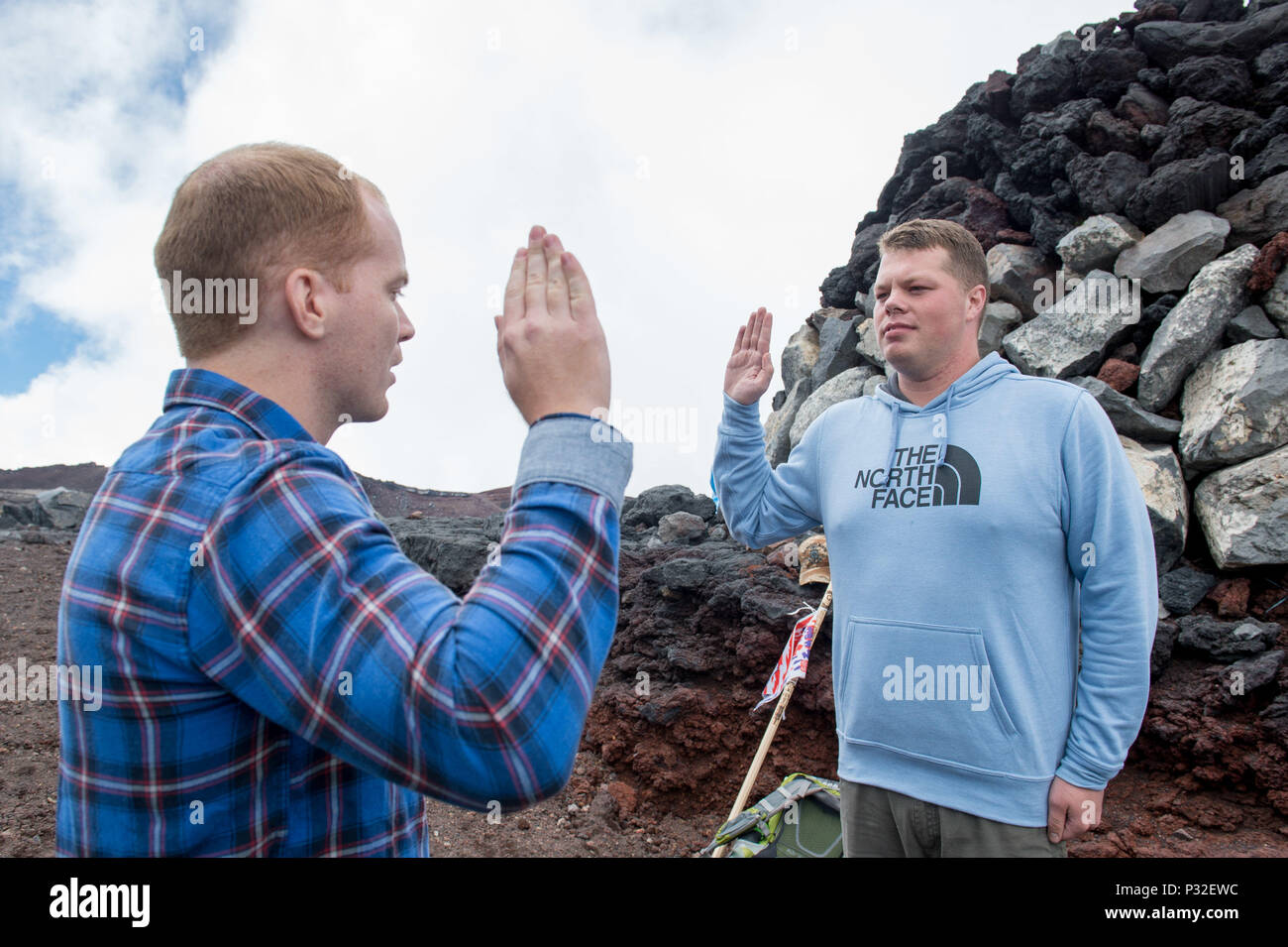 160825-N-UF697-396 MT. FUJI, Japan  (August 25, 2016) Cryptologic Technician (Collection) 2nd Class Elijah D. Stotts, right, from Pace, Fla., stationed at Navy Information Operations Command (NIOC) Hawaii reenlists with Lt.j.g. Christopher M. Jozwiak, left, from Fort Wayne, Ind., at the 12,389 foot summit of Mt. Fuji. Both Stotts and Jozwiak are temporarily assigned to the forward-deployed Arleigh Burke-class guided-missile destroyers USS Barry (DDG 52) and USS Benfold (DDG 65), respectfully, as a part of NIOC direct support teams. (U.S. Navy photo by Mass Communication Specialist 2nd Class Ke Stock Photo