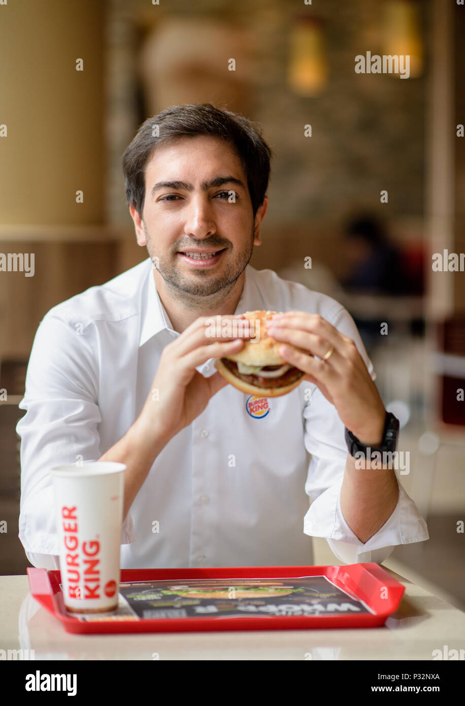 15 June 2018, Germany, Munich: Carlos Eduardo Baron, Burger King's manager in Germany, eats a burger during an interview. Photo: Matthias Balk/dpa Stock Photo