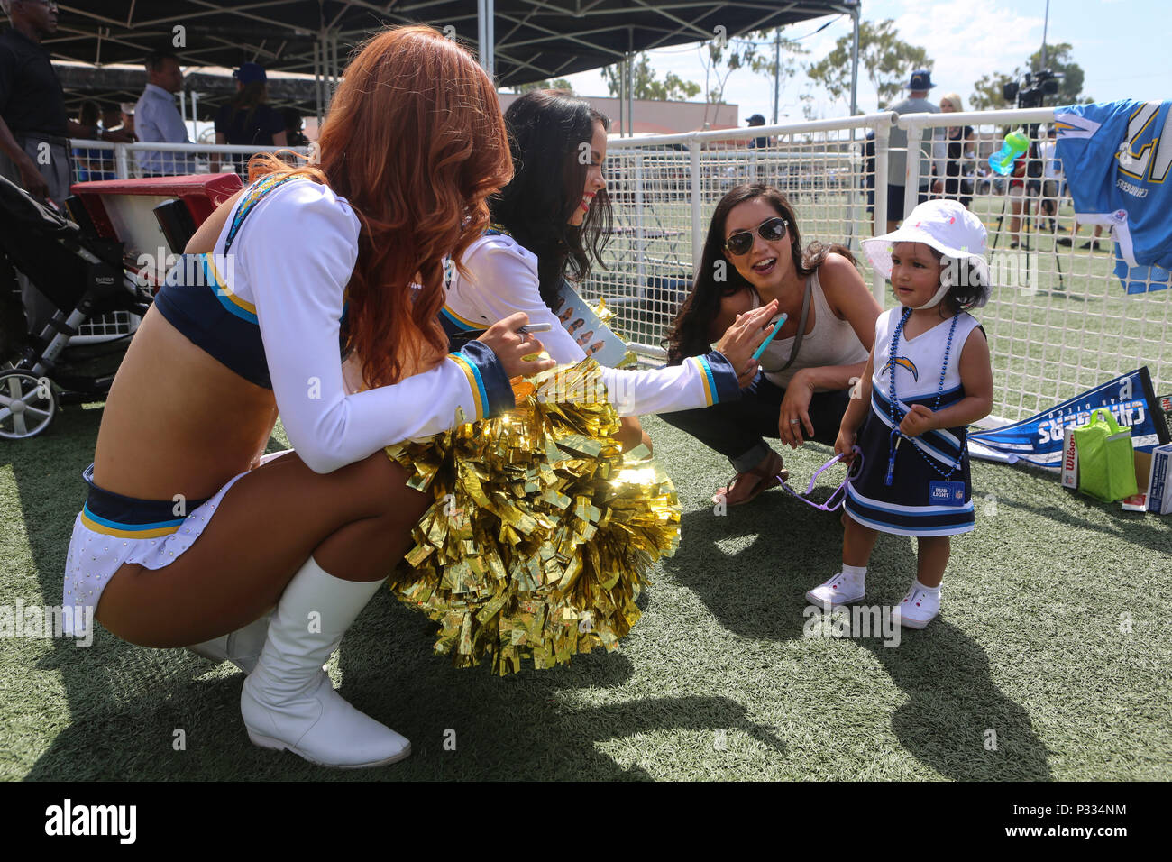 San Diego Chargers cheerleaders greet a service members family during the Chargers visit aboard MCAS Miramar, Calif., Aug. 31. While aboard the air station, the Chargers met service members and autographed various items for them. This event demonstrates the close ties between MCAS Miramar and the San Diego community. (U.S. Marine Corps photo by Lance Cpl. Harley Robinson/Released) Stock Photo