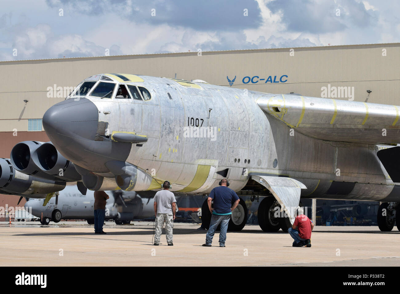 Maintenance personnel from the 565th Aircraft Maintenance Squadron work under and around B-52H 61-0007, 'Ghost Rider,' as the aircraft undergoes checks for an attempted functional test flight at the Oklahoma City Air Logistics Complex, Aug. 29, 2016, Tinker Air Force Base, Okla. 'OC-ALC' can be seen written on the hangar in the background as 'Ghost Rider' shines in natural metal as it completes a 19-month overhaul and upgrade to become the first B-52 to ever be regenerated from long-term storage with the 309th Aerospace Maintenance and Regeneration Group at Davis-Monthan AFB, Ariz., and return Stock Photo