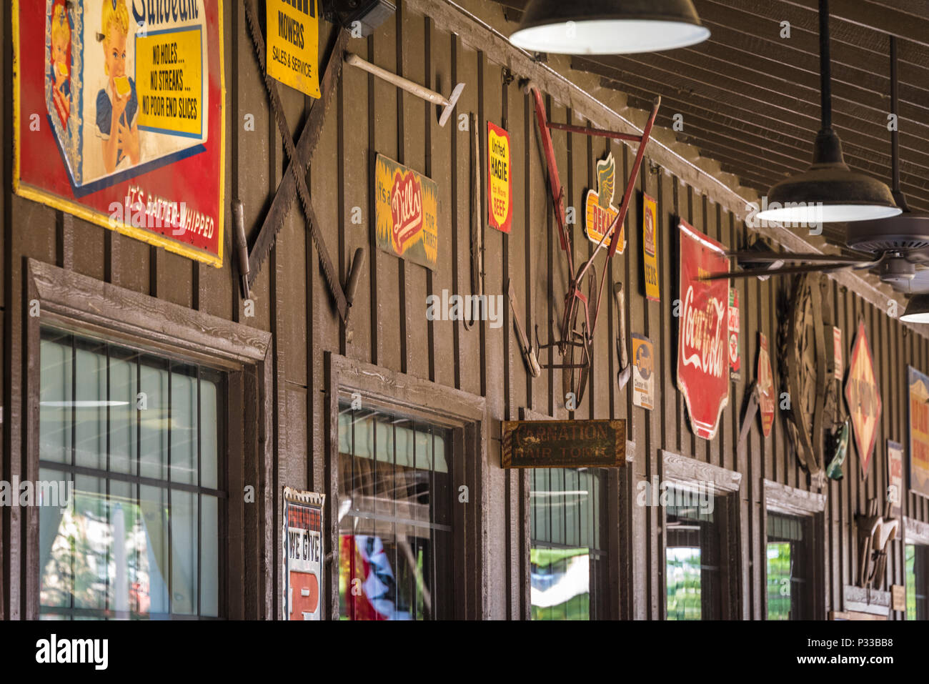 Vintage tin signs and farm tools adorn the the front porch wall at Cracker Barrel Old Country Store in Russellville, Arkansas. (USA) Stock Photo