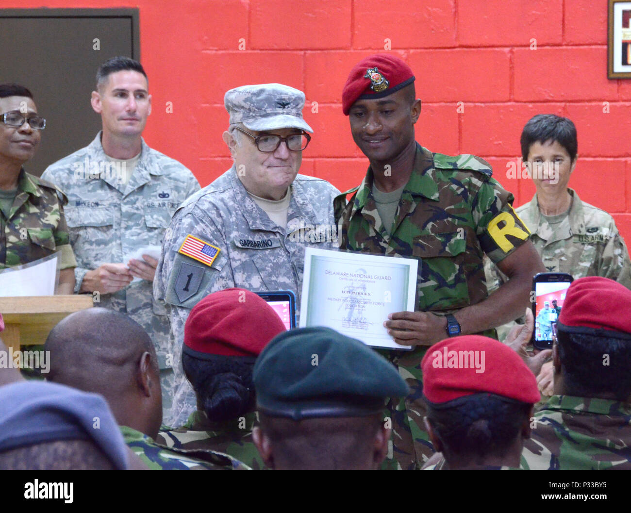 CHAGUARAMAS, Trinidad- Col. Charles L. Garbarinio, medical core, Delaware National Guard, presents Lance Corporal Patrick S. with an award prior to receiving his award during an award ceremony held on Aug. 11, 2016. ( U.S. Air National Guard photo by Tech. Sgt. Gwendolyn Blakley) Stock Photo
