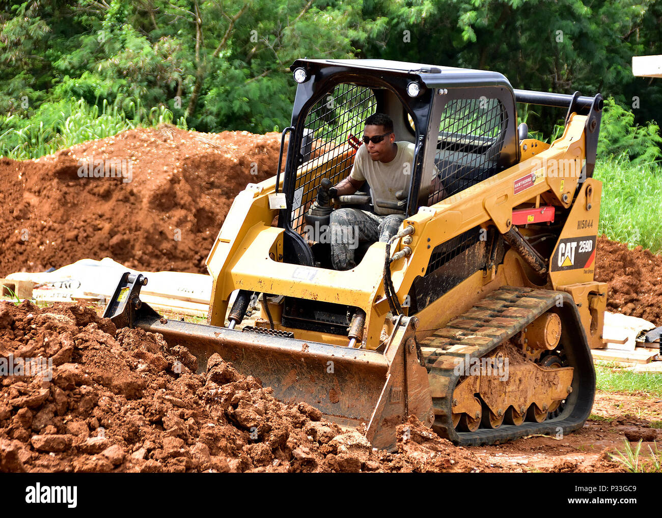 Staff Sgt. Bruno Ramos from the 143d Civil Engineering Squadron (CES), Rhode Island Air National Guard moves earth for a drainage trench in Inarajan, Guam during an Innovative Readiness Training (IRT) project on September 1, 2016.  The IRT project, in conjunction with Habitat for Humanity Guam is to provide two homes for residents in Inarajan.  The members are part of a 36 Airmen crew from a cross section of trades within the CES.  U.S. Air National Guard photo by Master Sgt. John V. McDonald Stock Photo