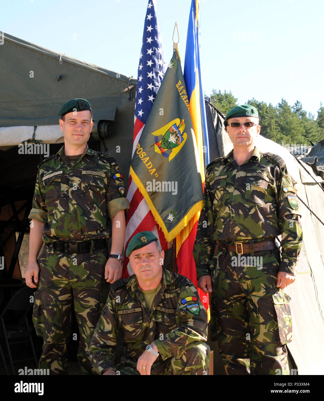 Soldiers from the Romanian Army proudly stand by their flag as they wait for their main convoy to arrive at the Joint Multinational Readiness Center in Hohenfels, Germany Aug. 31, 2016, for Exercise Combined Resolve VII, which is a 7th Army Training Command, U.S. Army Europe-directed exercise, taking place at the Grafenwoehr and Hohenfels Training Areas, Aug. 8 to Sept. 15, 2016. The exercise is designed to train the Army’s regionally allocated forces to the U.S. European Command. Combined Resolve VII includes more than 2,500 participants from 16 NATO and European partner nations. (U.S. Army p Stock Photo