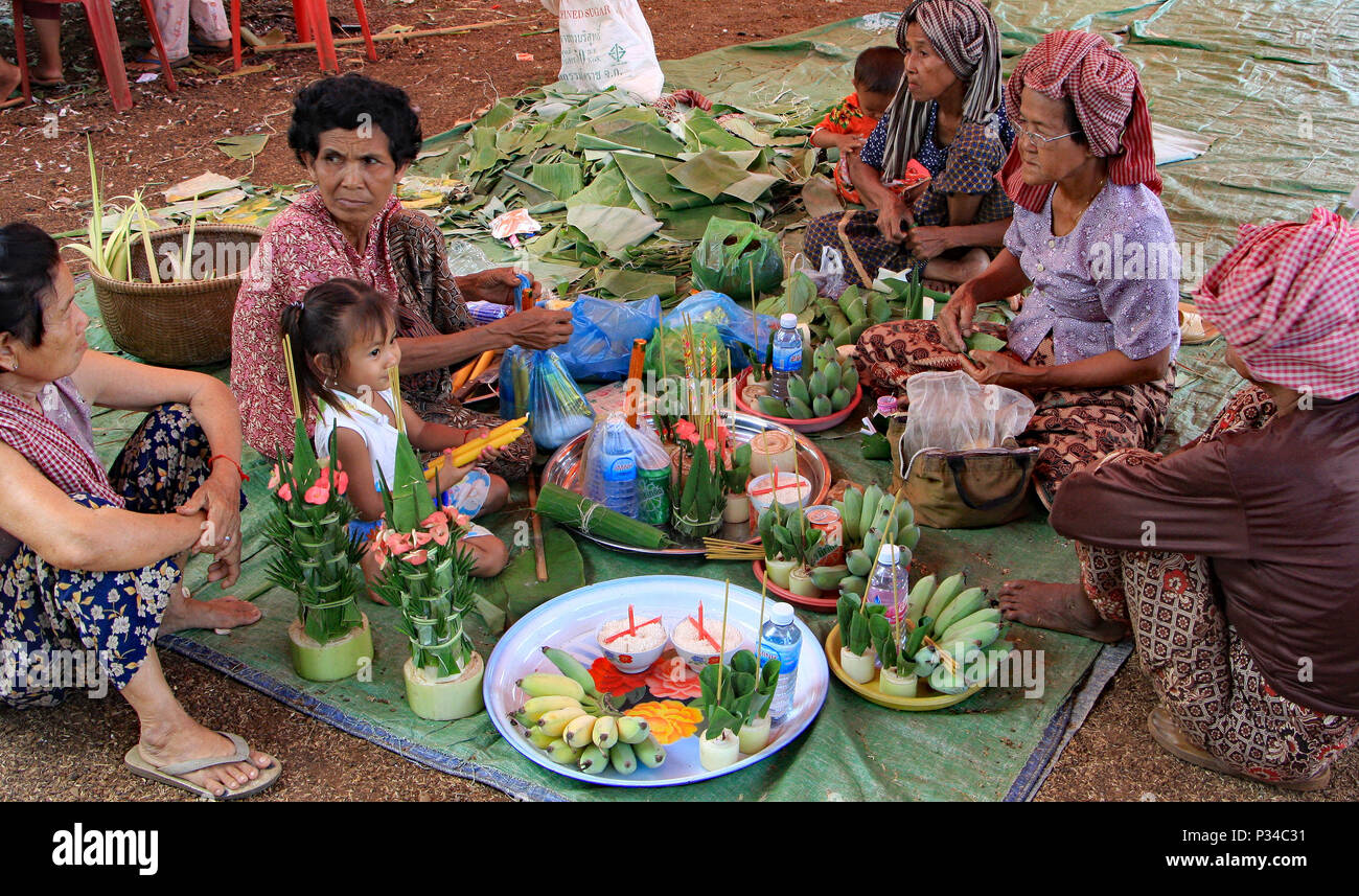 The family preparing food, table decorations and gifts for Buddha, ready for the wedding the next day. Stock Photo