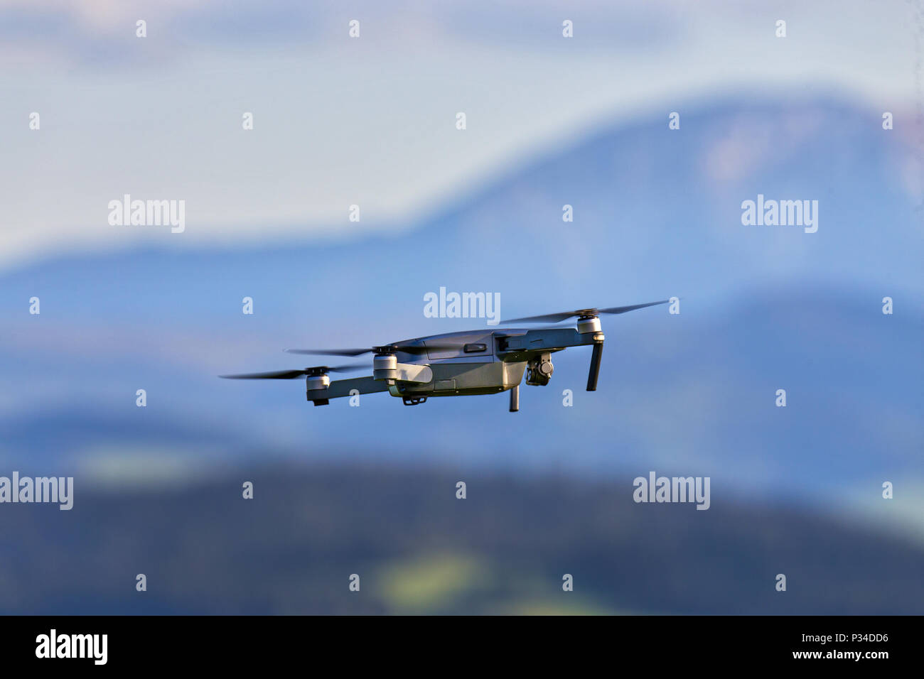 Drone with camera flying over mountain fields. Aerial photography and videography. Drone quad copter with high resolution digital camera in the air Stock Photo