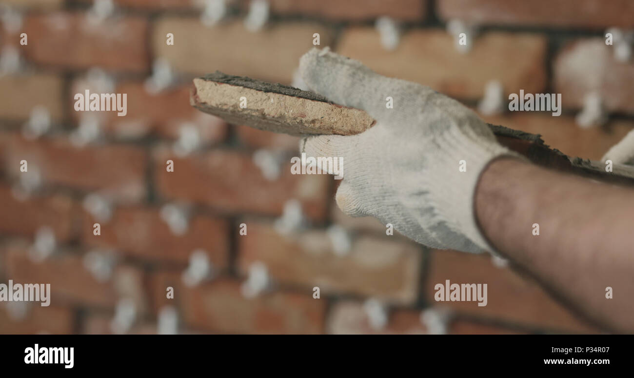 closeup worker applying concrete glue to brick tile, wide photo Stock Photo Alamy