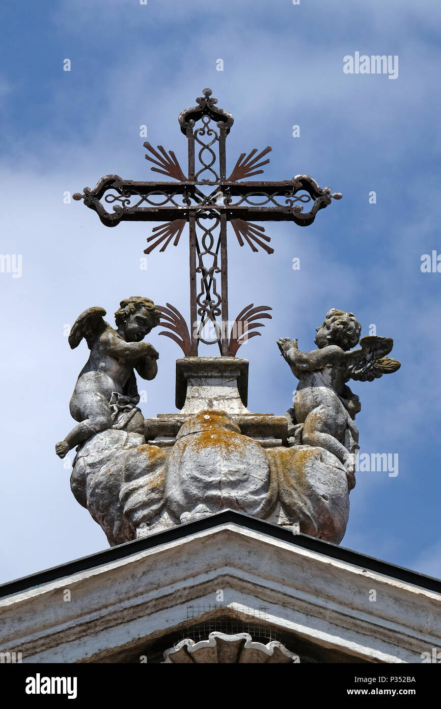 Angels kneeling under the cross, statue on facade of the Mantua Cathedral dedicated to Saint Peter, Mantua, Italy Stock Photo