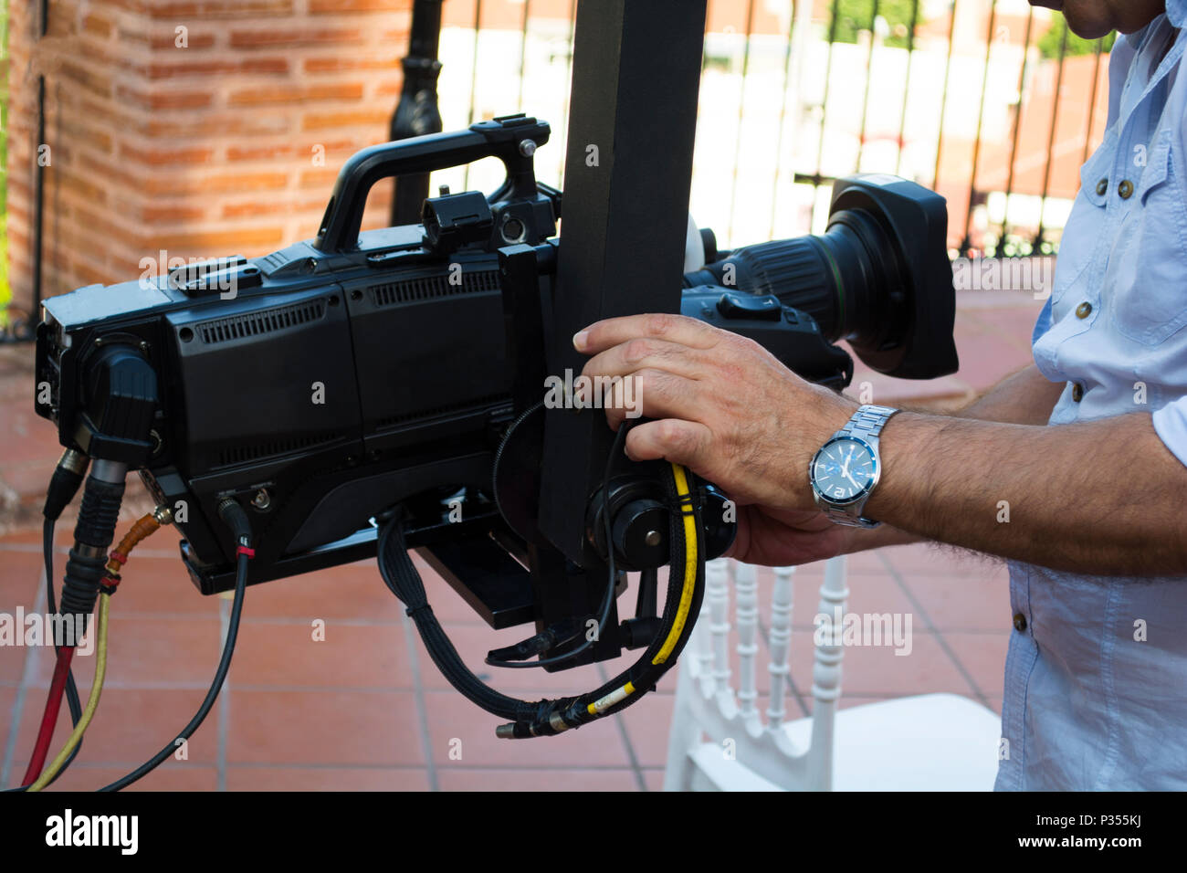 Cameraman checking equipment of camera in broadcast television green
