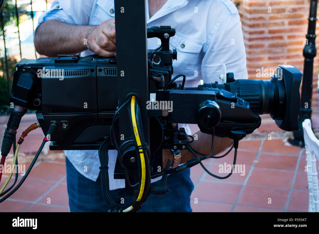 Cameraman checking equipment of camera in broadcast television green