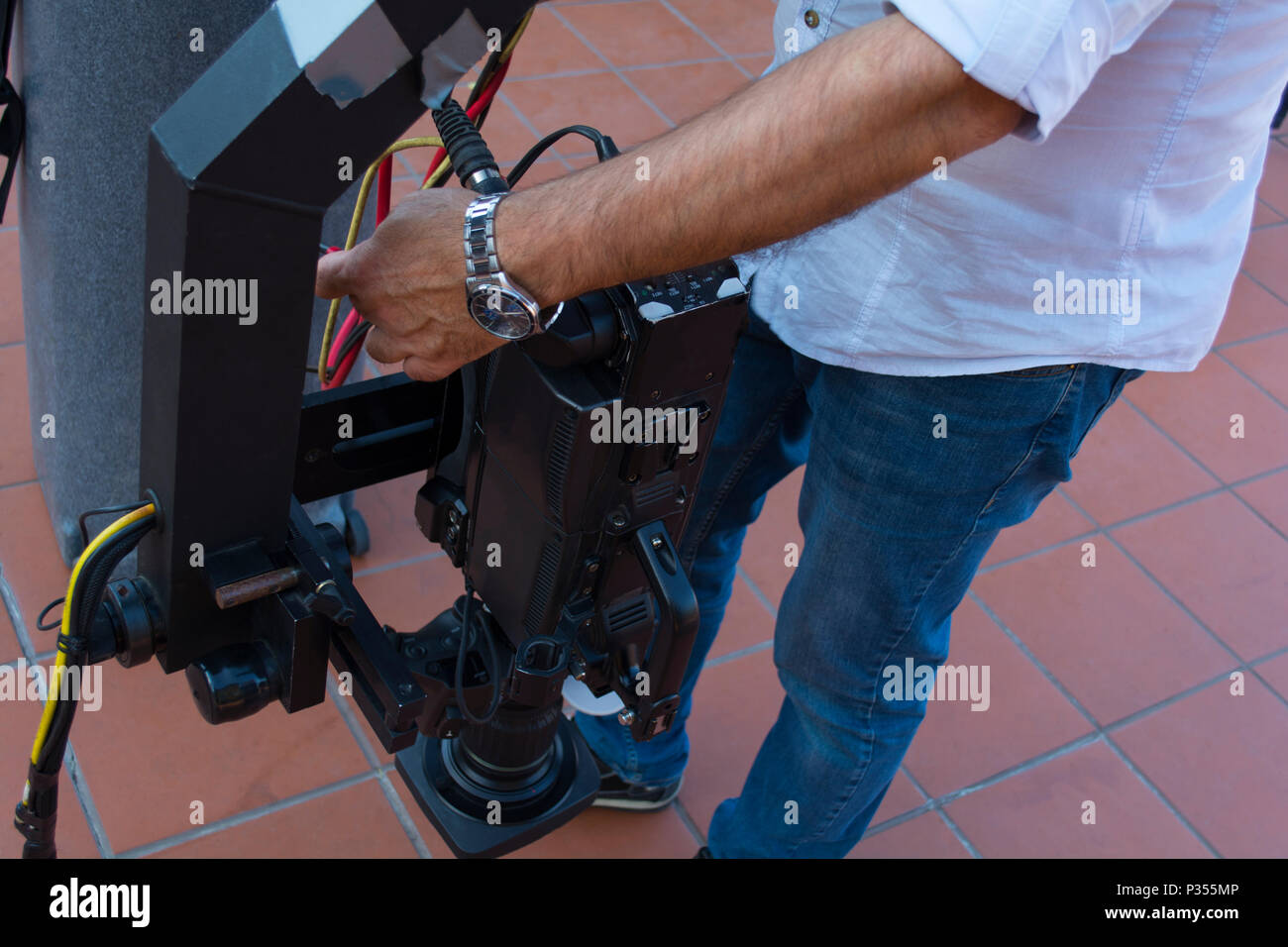 Cameraman checking equipment of camera in broadcast television green