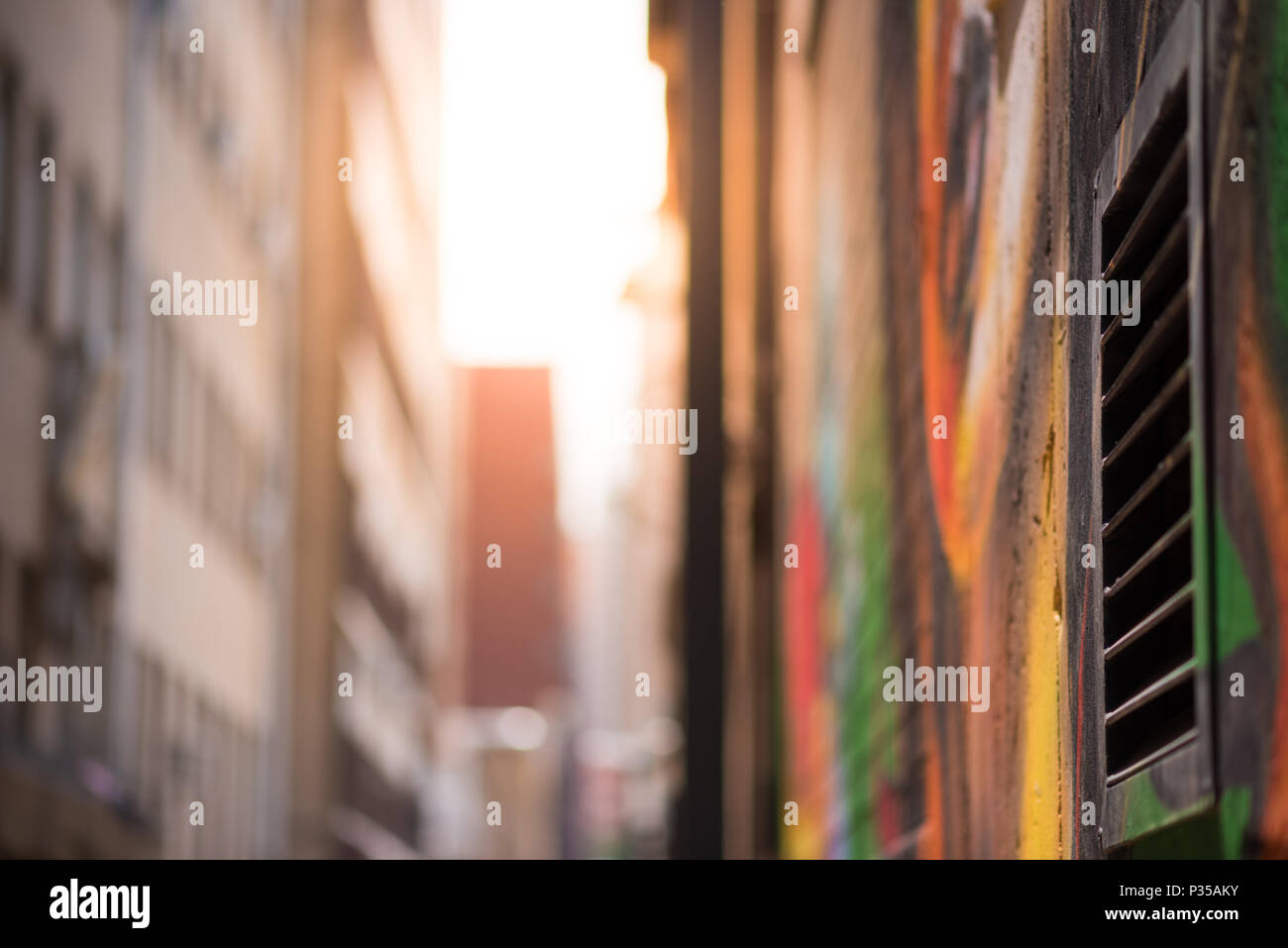 Abstract style photograph looking down a graffiti lined alley way towards the sun. Johannesburg inner city Stock Photo