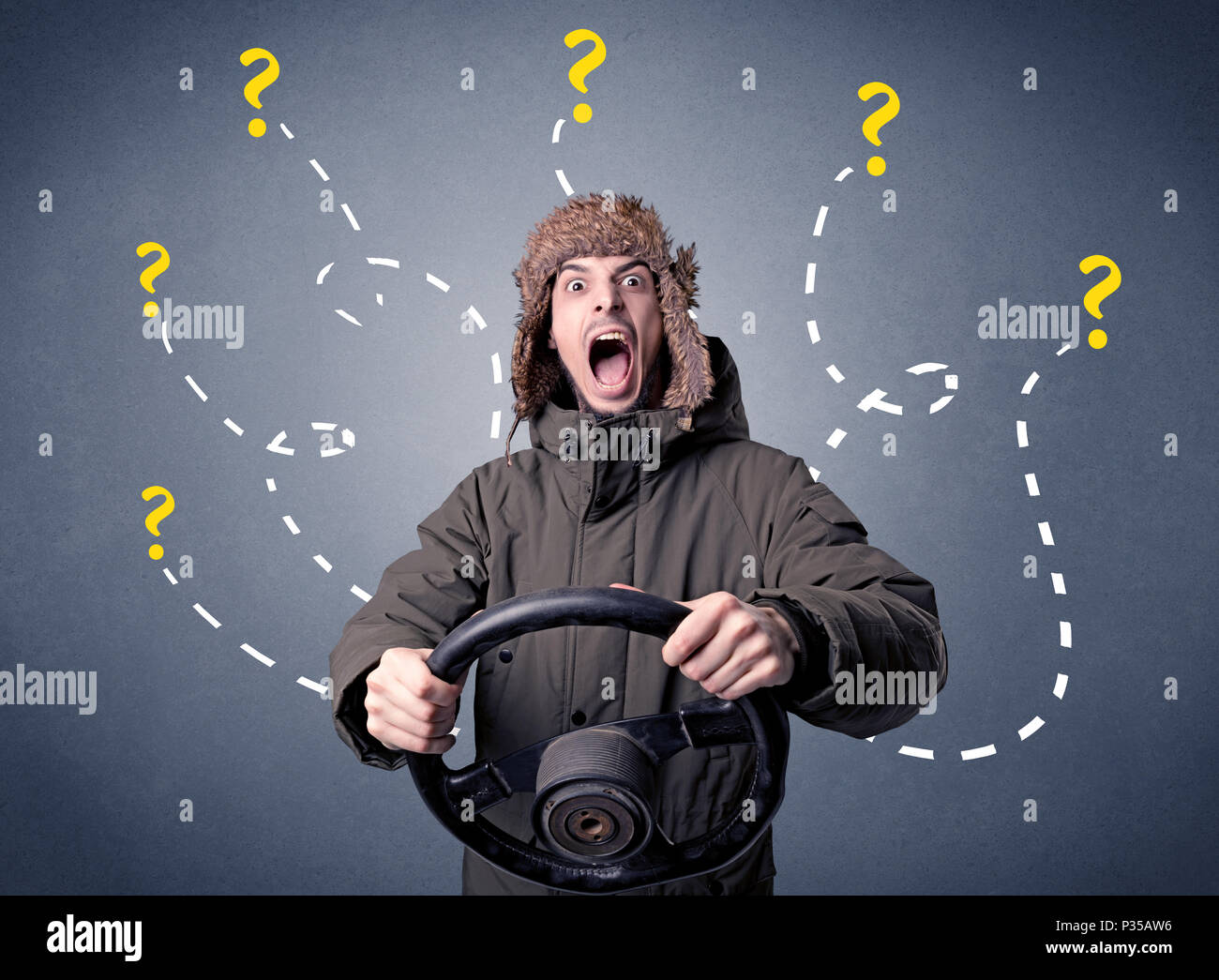 Young man holding black steering wheel with question marks around him