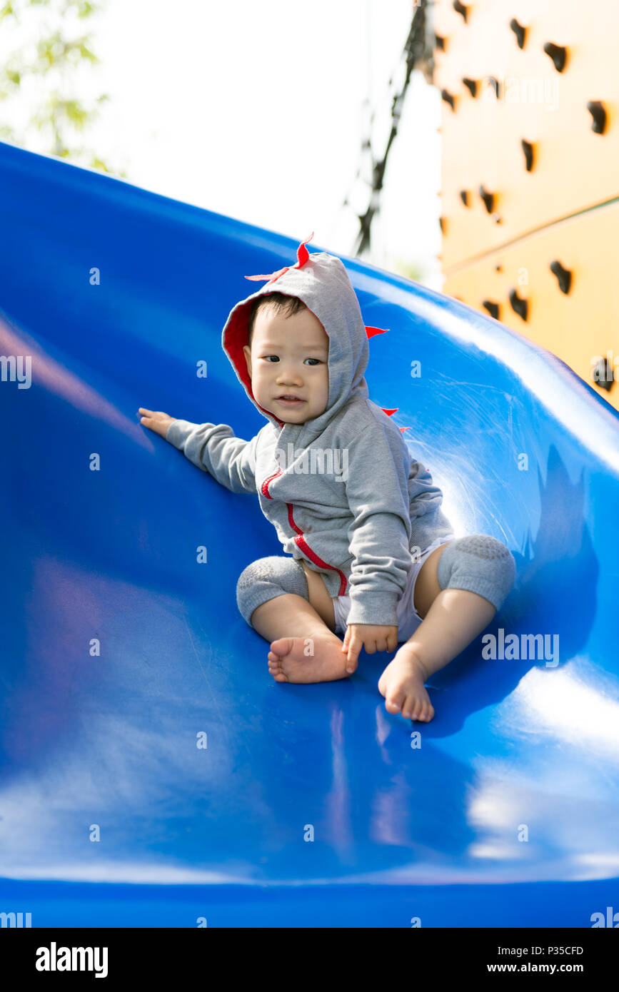 Small Asian baby boy playing slide Stock Photo